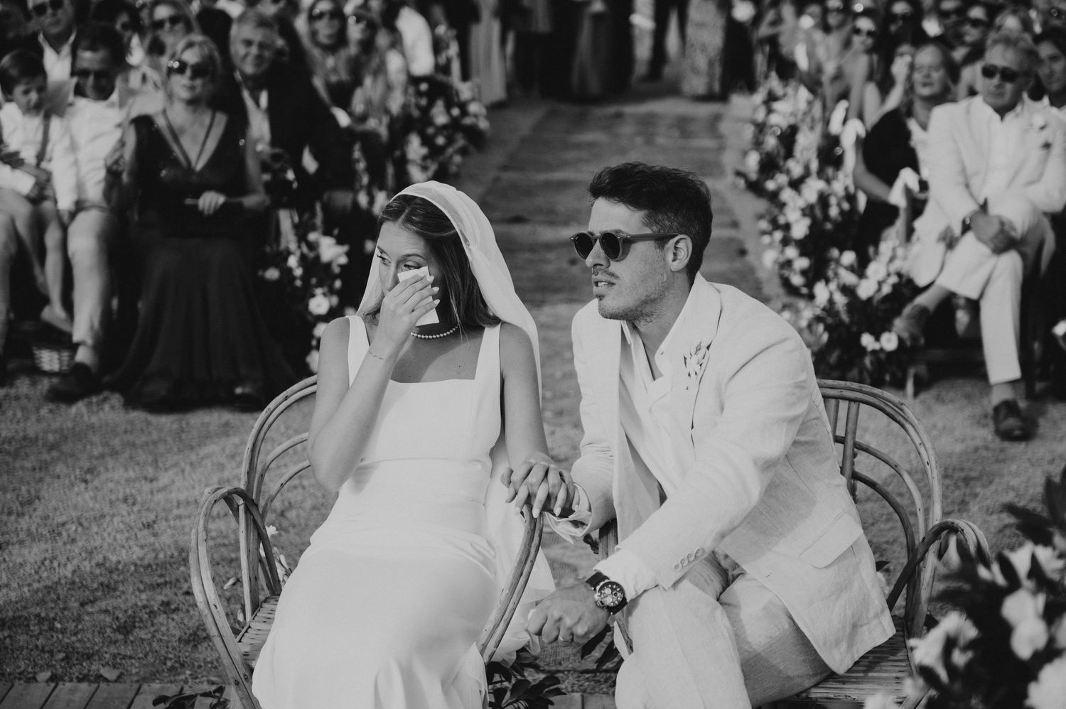 Black and white photo of emotional bride wiping tears during outdoor wedding ceremony. Emotional wedding vows in Mendoza.