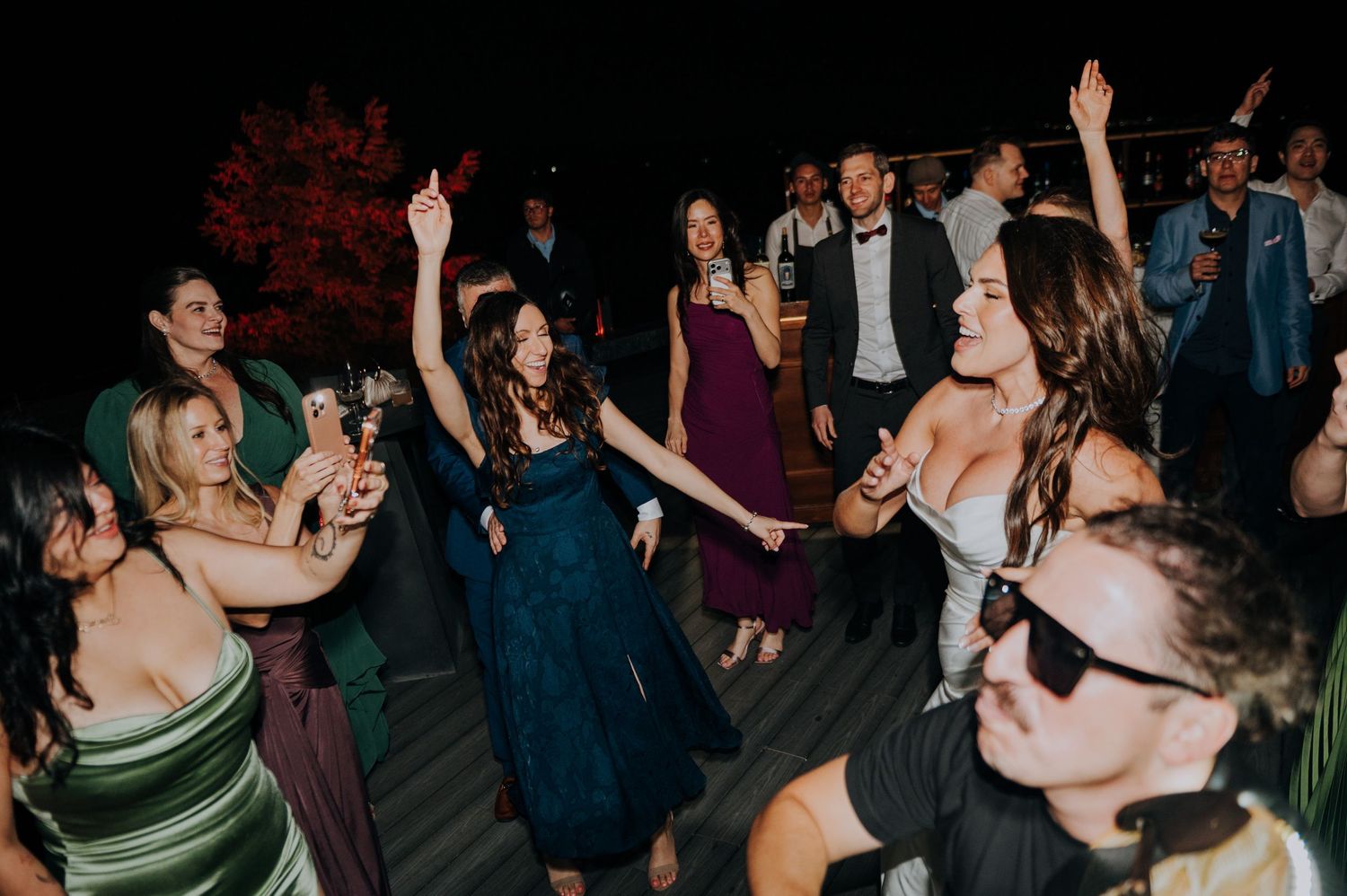 Wedding guests dancing and celebrating at an outdoor evening wedding reception party.