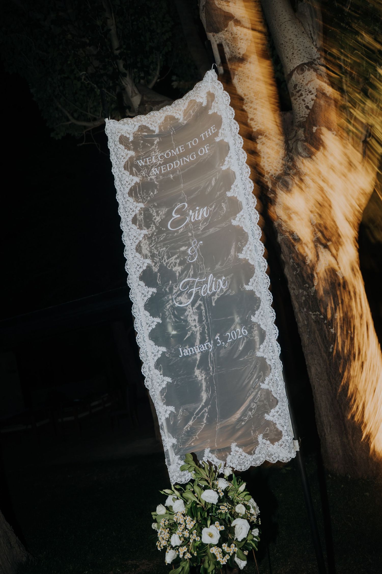 Elegant acrylic wedding welcome sign reading Erin and Felix January 3 2026 with lace detail.