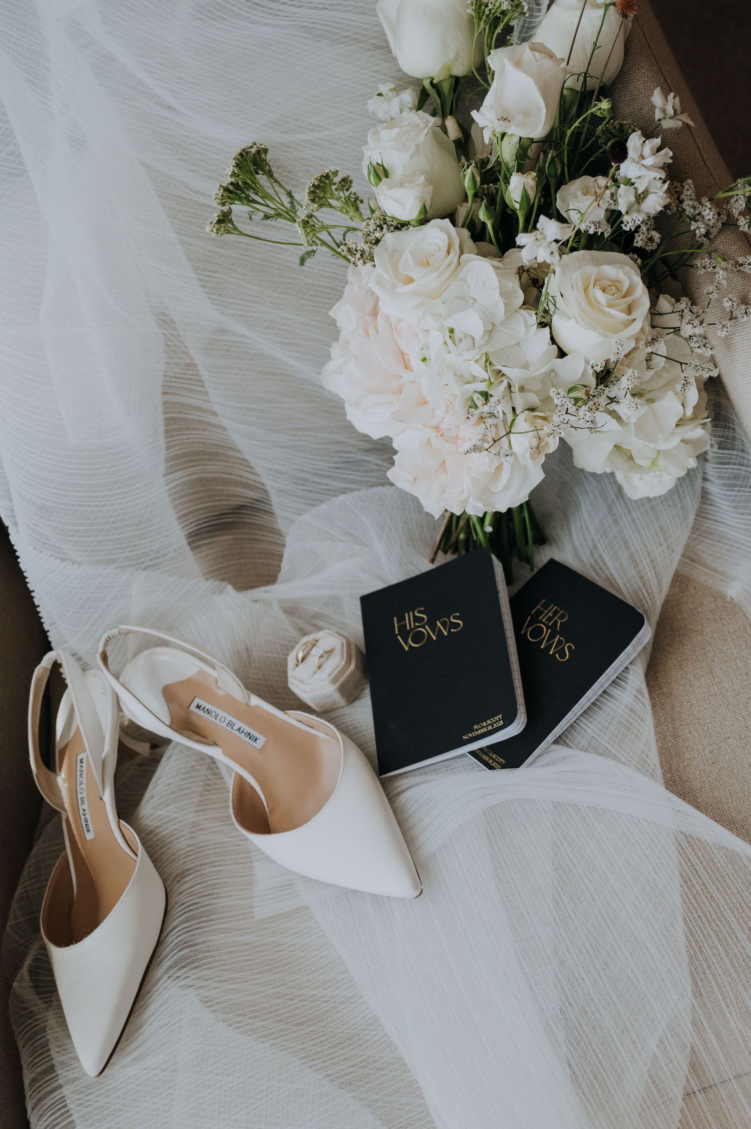 Elegant bridal flat lay with white roses bouquet, Manolo Blahnik heels, and vow books in mendoza