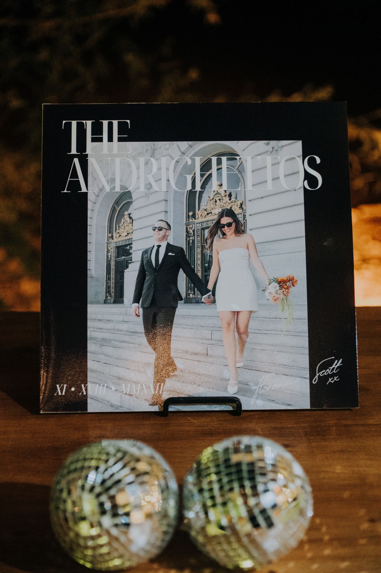 Custom vinyl record wedding sign for The Andrighettos displayed with disco balls.