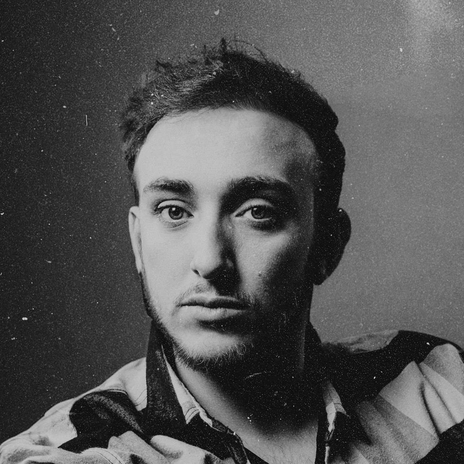 Black and white close-up portrait of young man with intense gaze. wedding photographer in mendoza