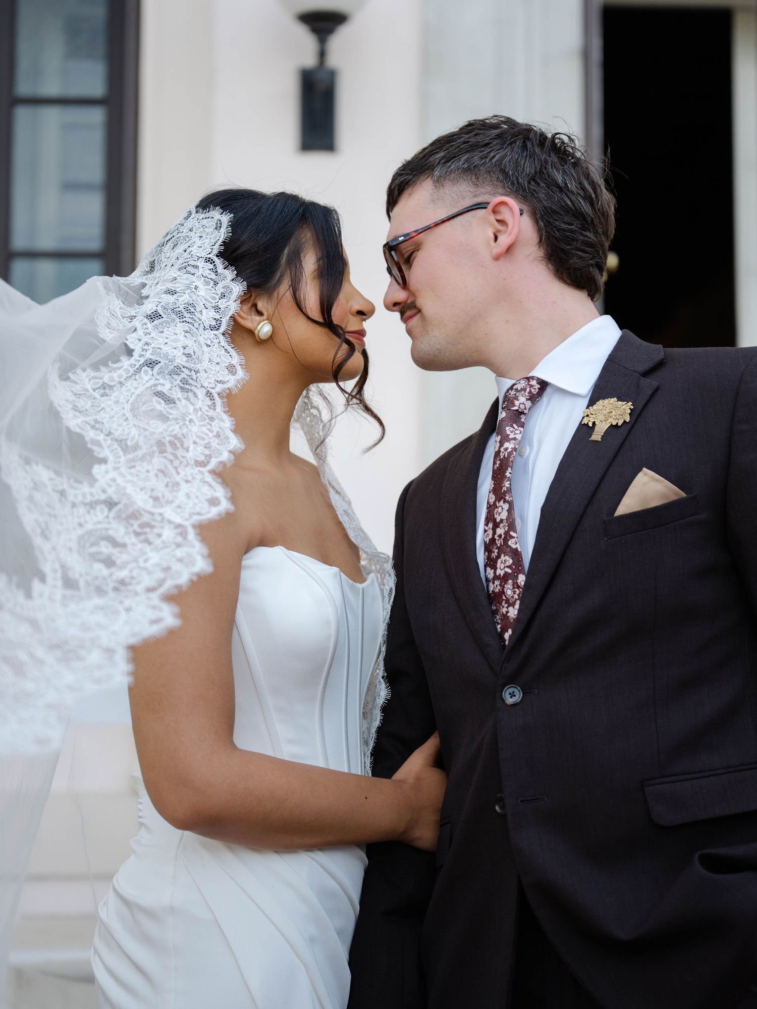 Bride and groom share romantic moment, nearly kissing, bride in strapless gown with lace mantilla veil. Geneva On The Lake