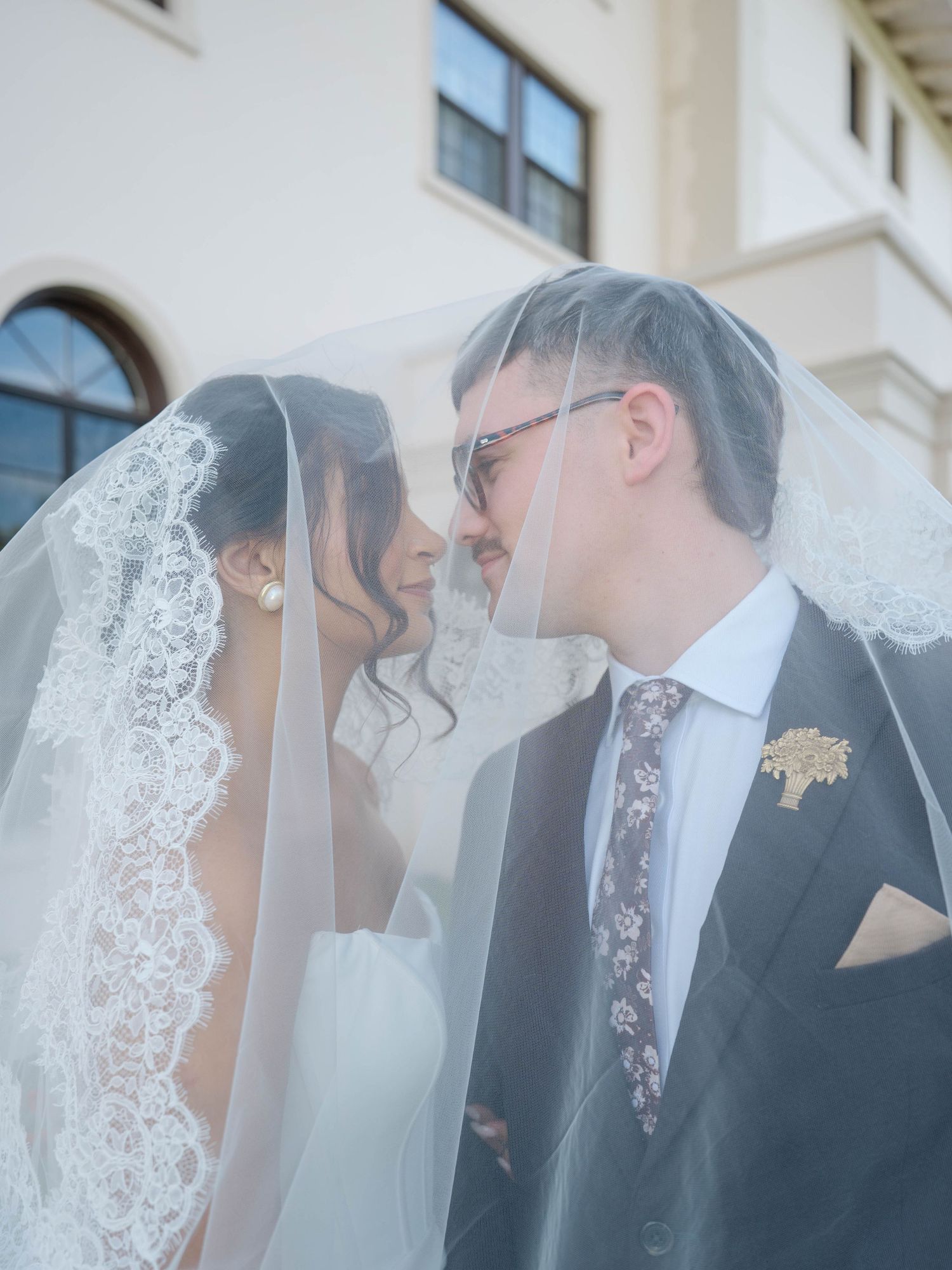 Romantic wedding portrait of bride and groom nearly kissing beneath a flowing lace-trimmed bridal veil. finger lakes wedding