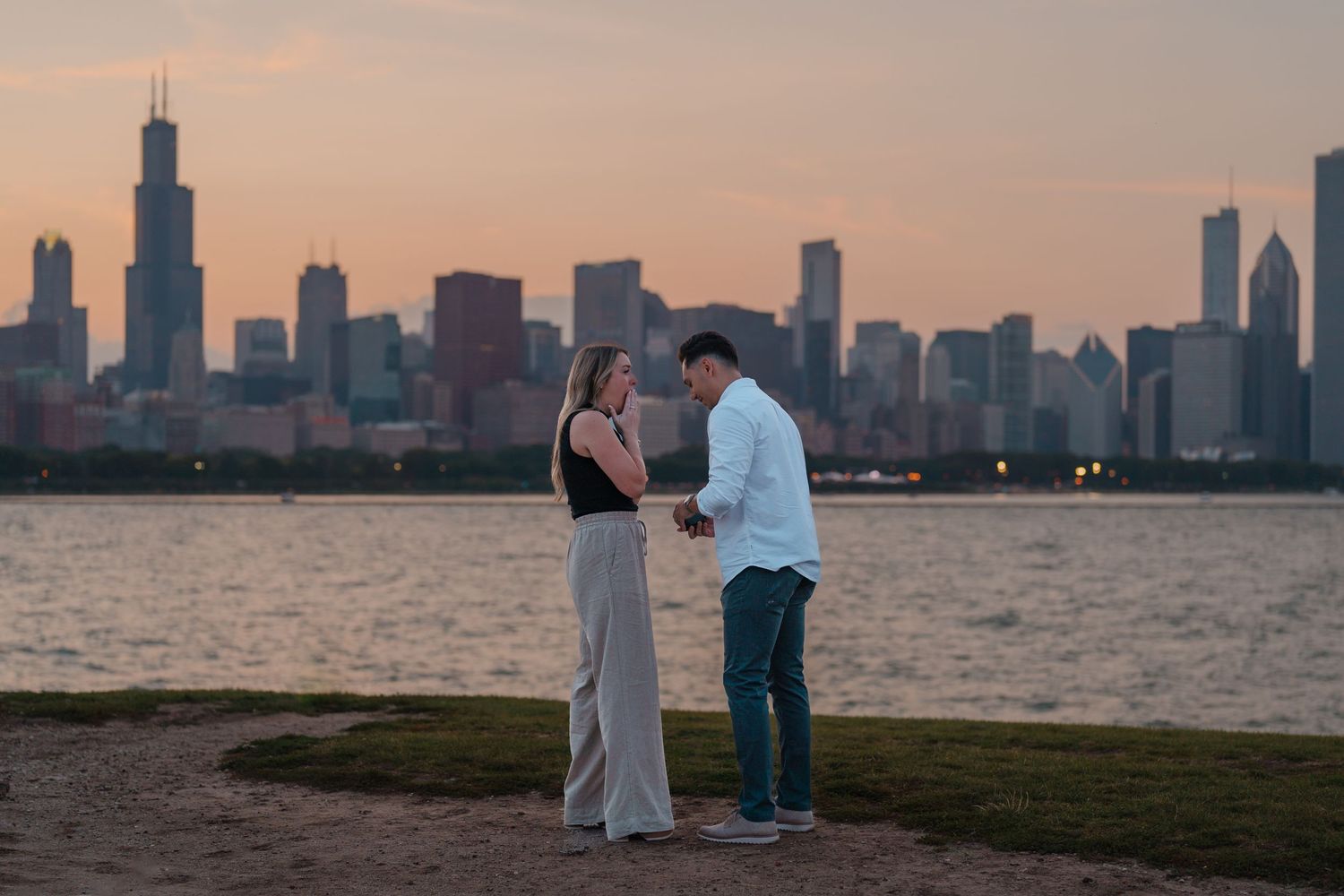 Couple sharing a romantic moment at dusk with Chicago city skyline in background.