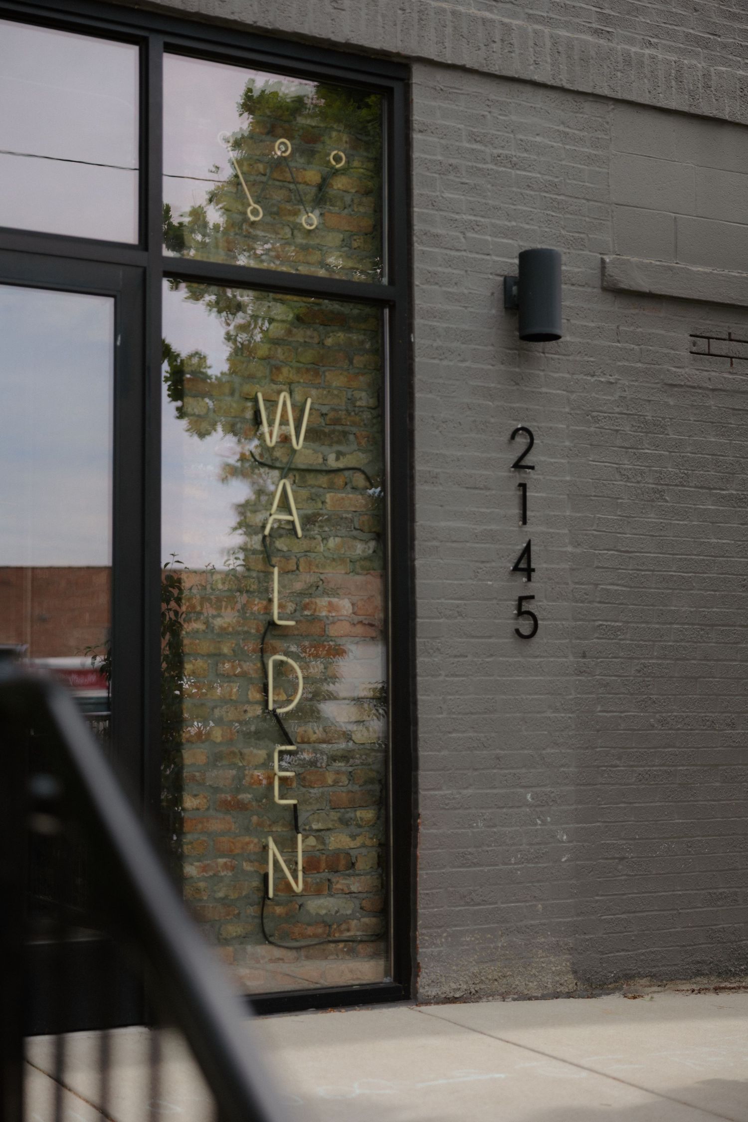 Walden restaurant exterior at 2145 with neon vertical sign in window on gray brick building.