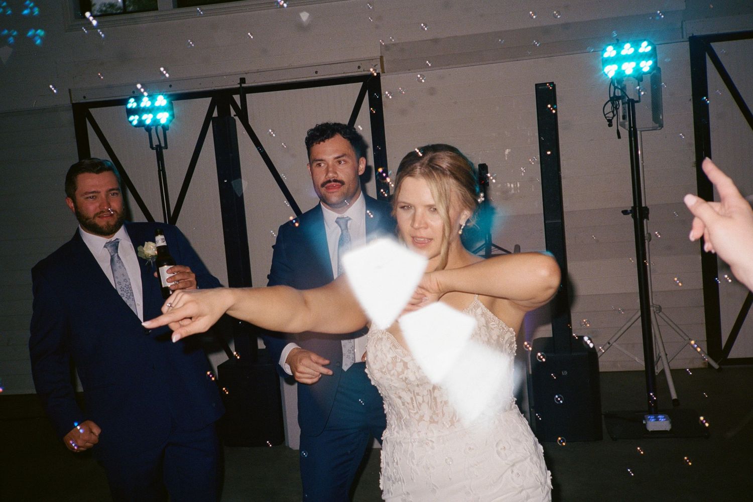 Bride and groom celebrate with sparklers and confetti on the wedding dance floor.