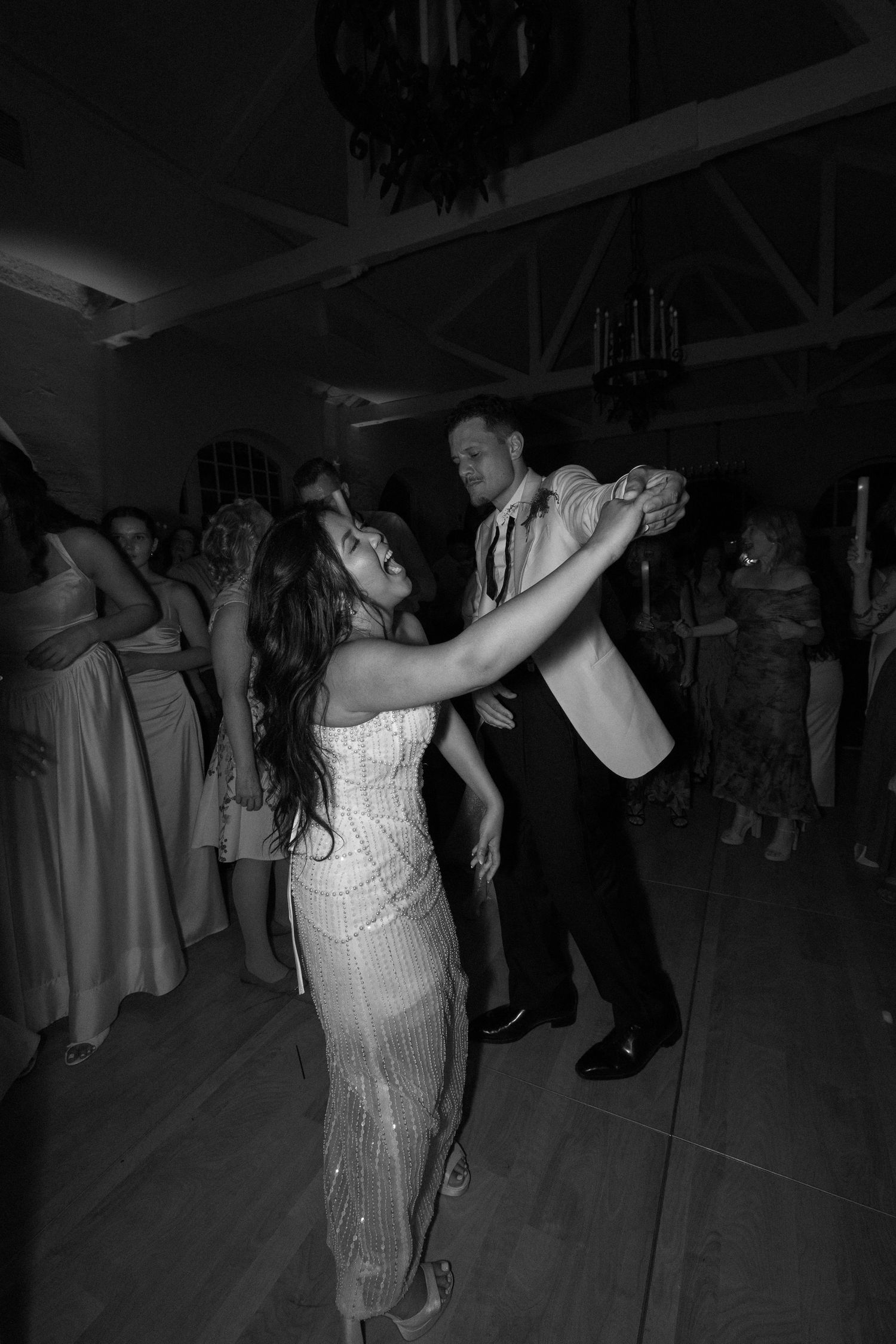 Bride and groom share a joyful dance together at their black and white wedding reception.