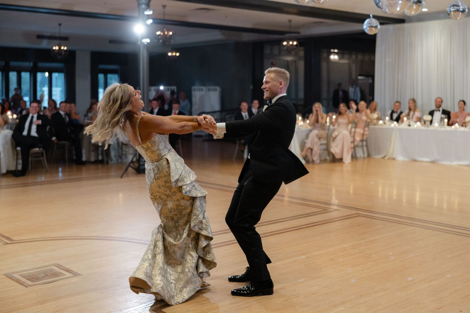Bride and her father share a lively, joyful dance on the wedding reception dance floor.