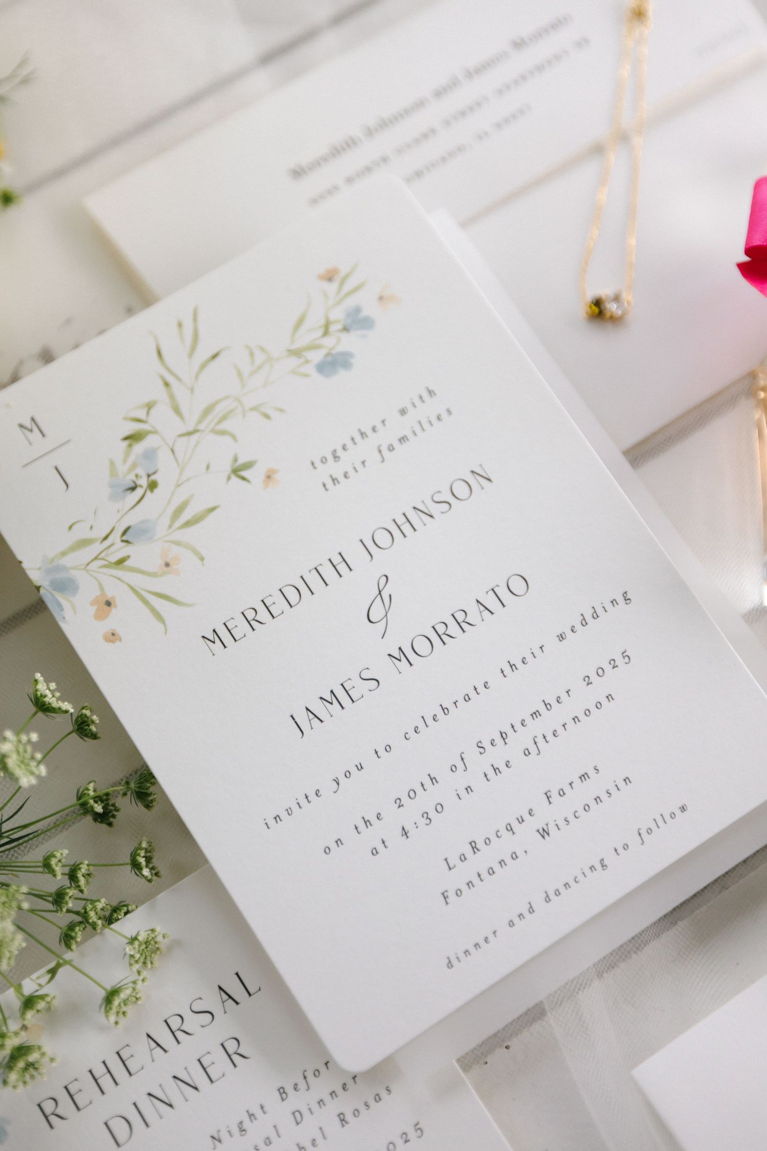 Elegant wedding invitation for Meredith Johnson and James Morrato featuring watercolor floral details for September 2023.