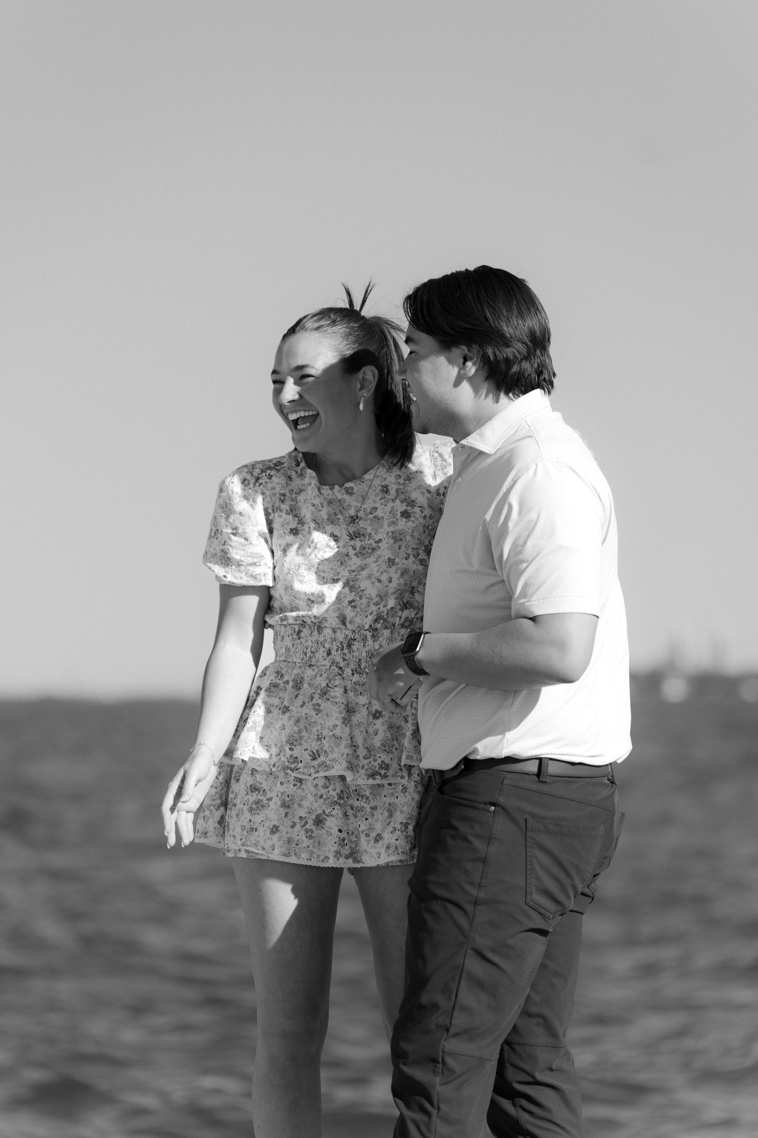 Black and white photo of happy couple embracing on Chicago lakefront on a sunny day.