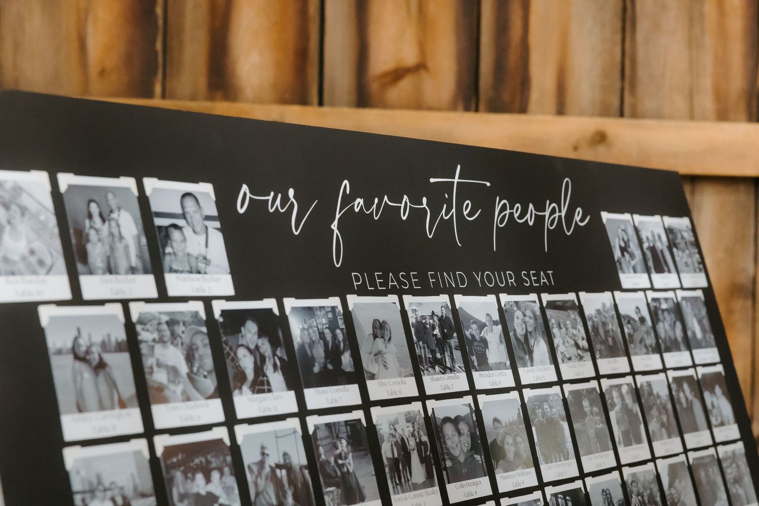 Black seating chart board with photos labeled our favorite people please find your seat.