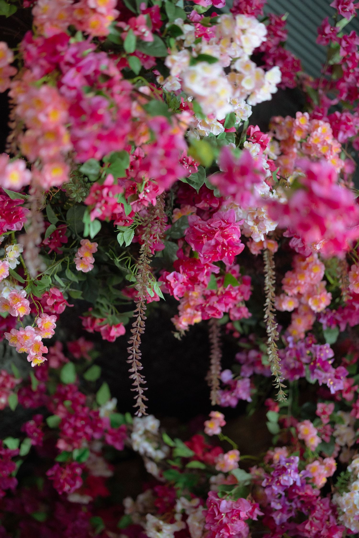 Lush arrangement of vibrant pink, white, and peach flowers with green leaves, creating a stunning floral display.