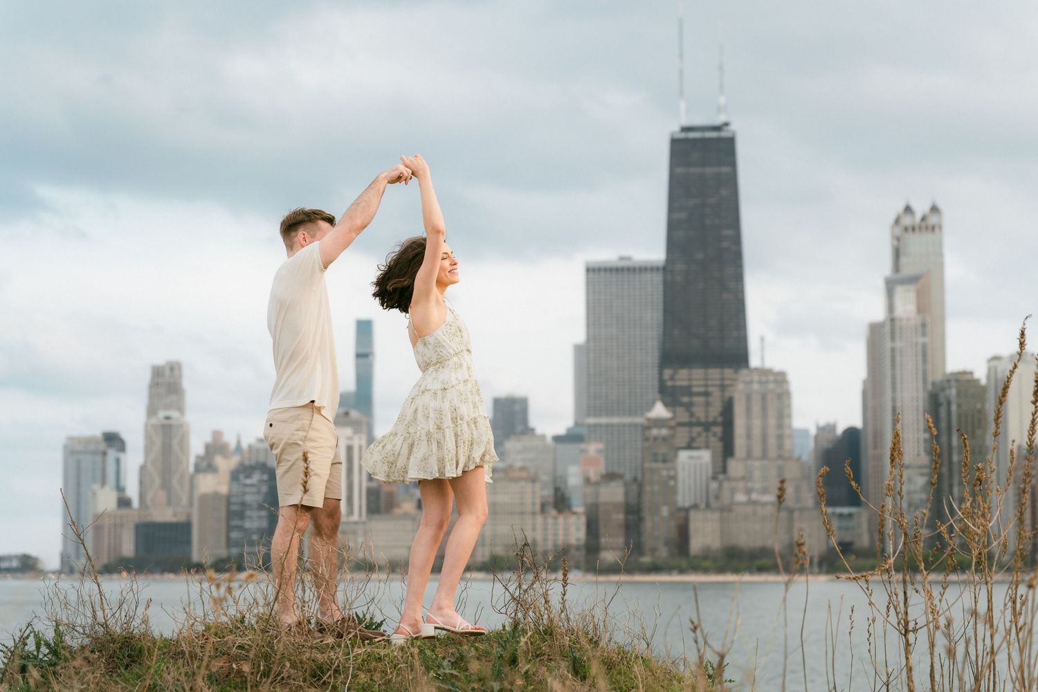 Couple dancing together with Chicago skyline and lake Michigan behind them.
