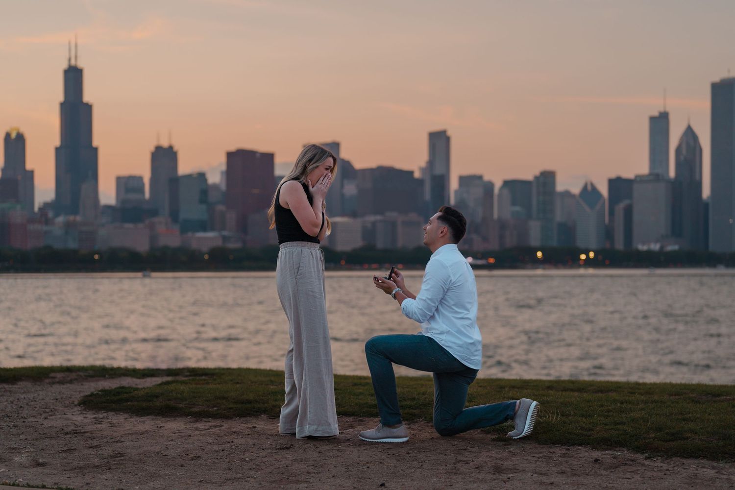 Romantic marriage proposal at sunset with iconic Chicago skyline along the waterfront.
