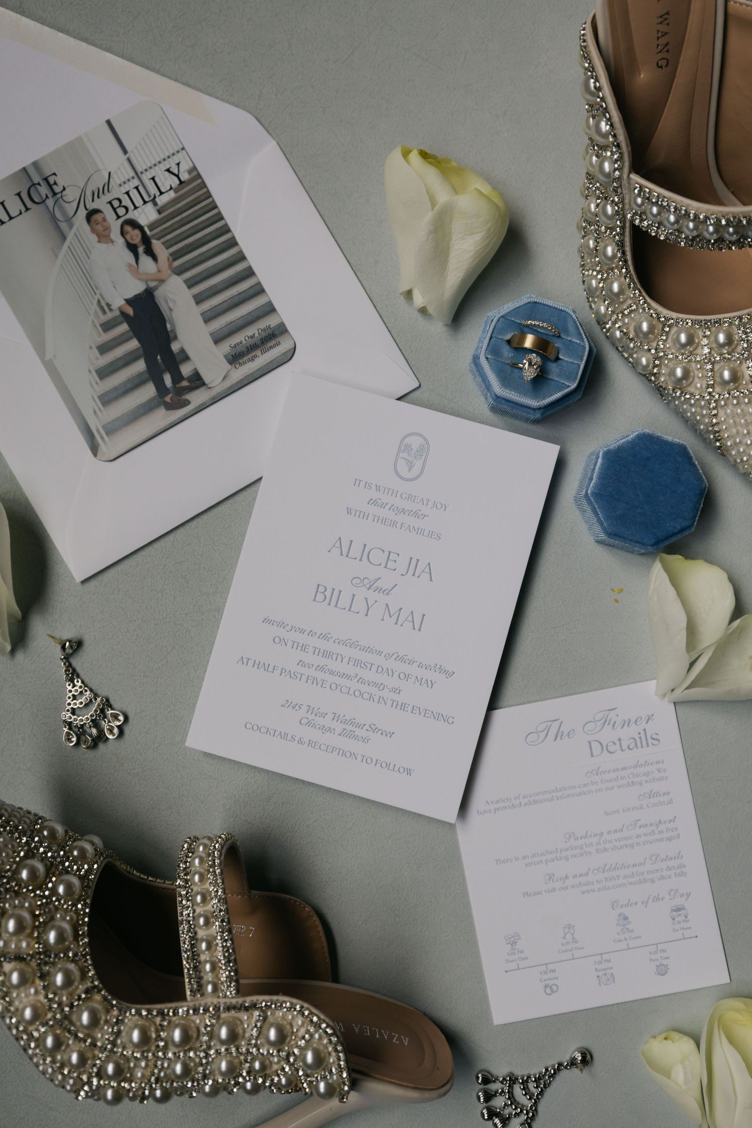 Elegant wedding stationery flatlay with pearl shoes, blue velvet ring box, and floral accents for Alice and Billy Mai.