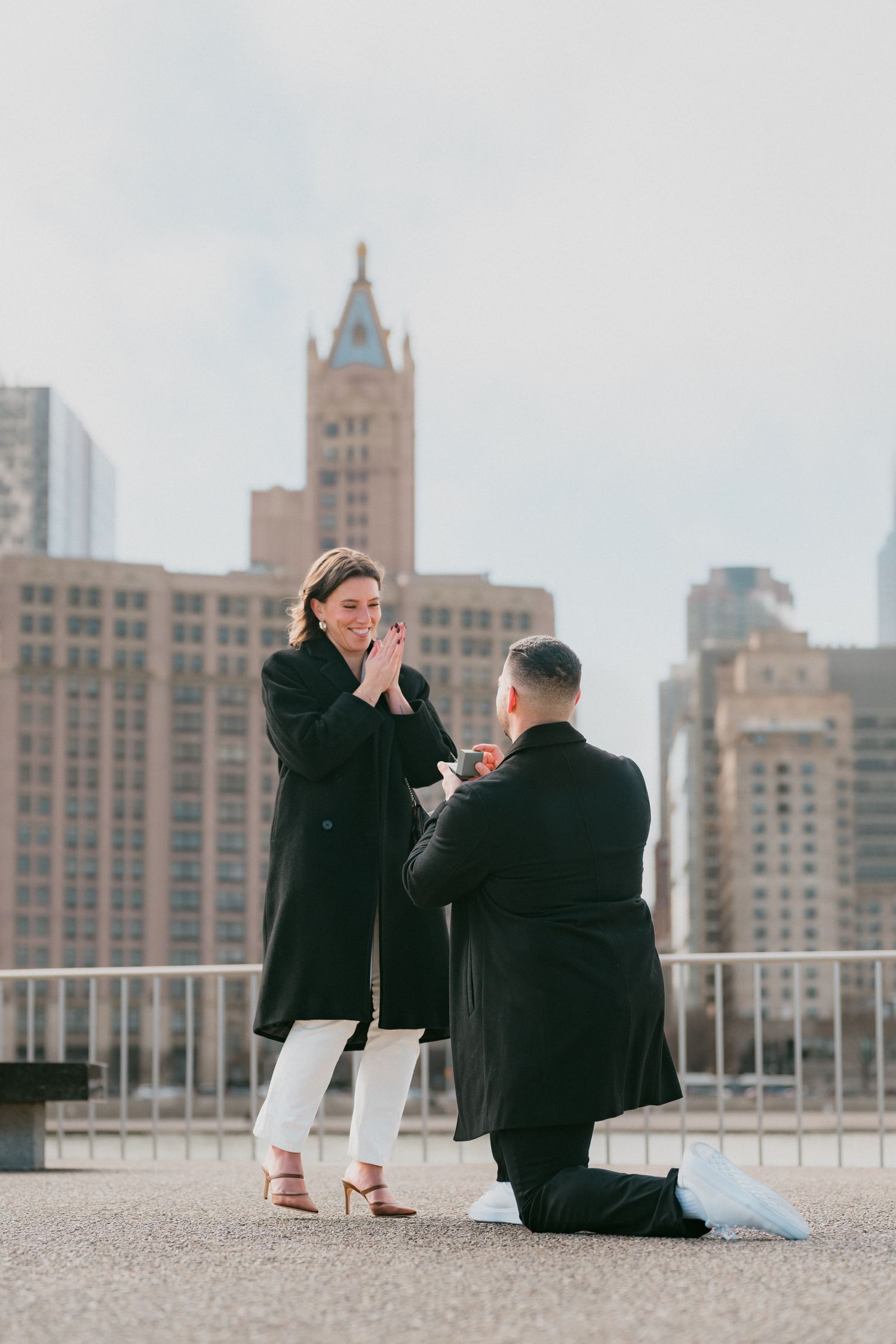 Emotional marriage proposal moment with man on one knee presenting ring to woman in Chicago.
