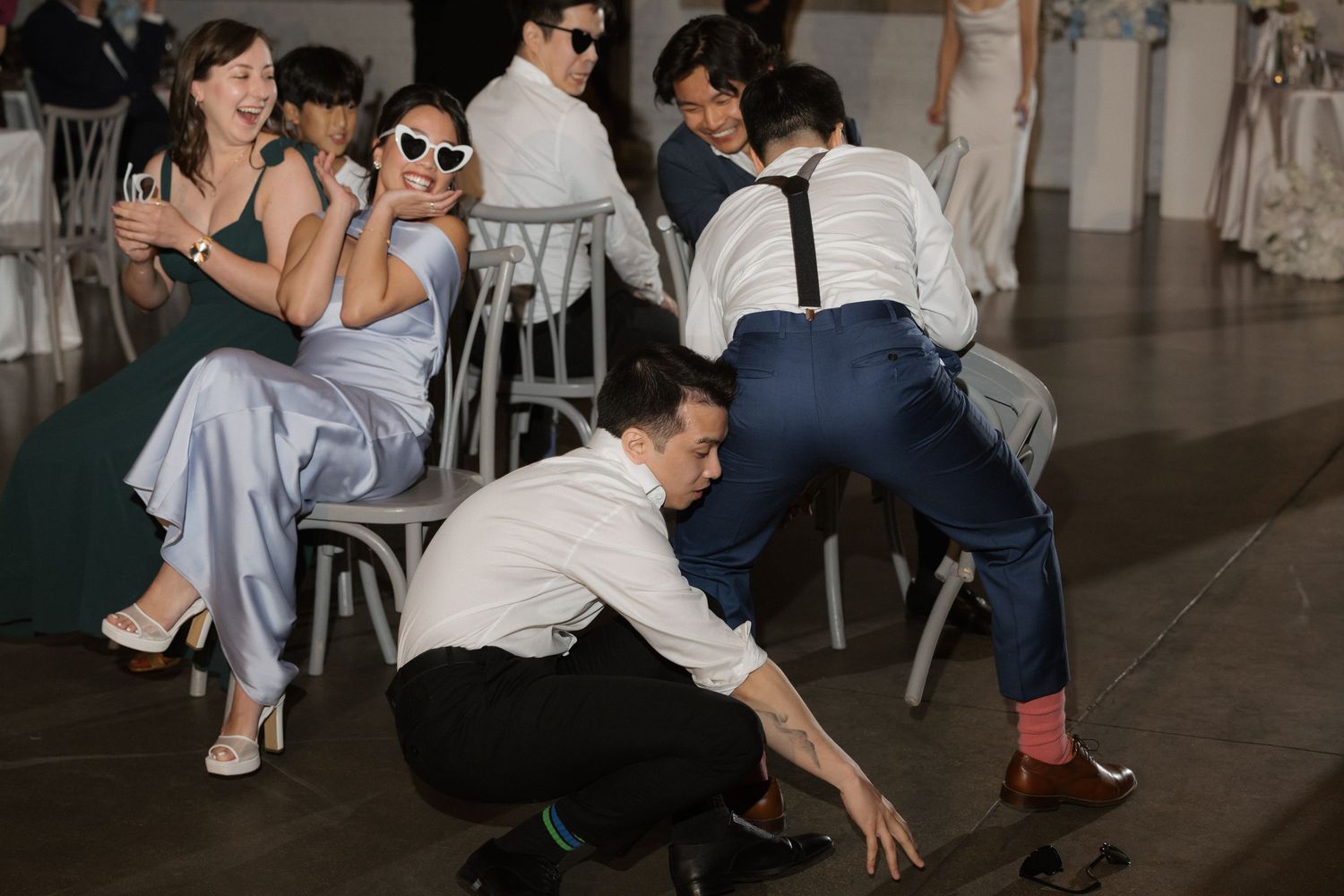 Wedding guests playing a fun shoe game on the dance floor at a reception.