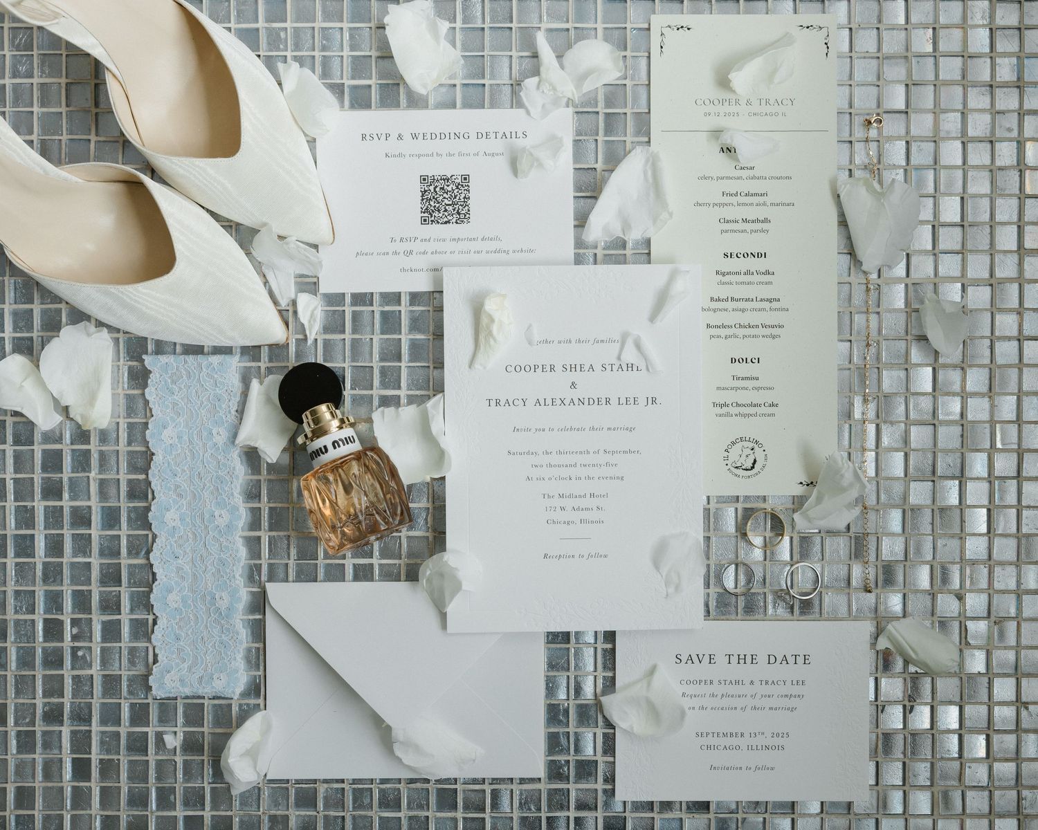 Elegant wedding stationery suite with save the date cards, menu, and envelope displayed with white heels and perfume.