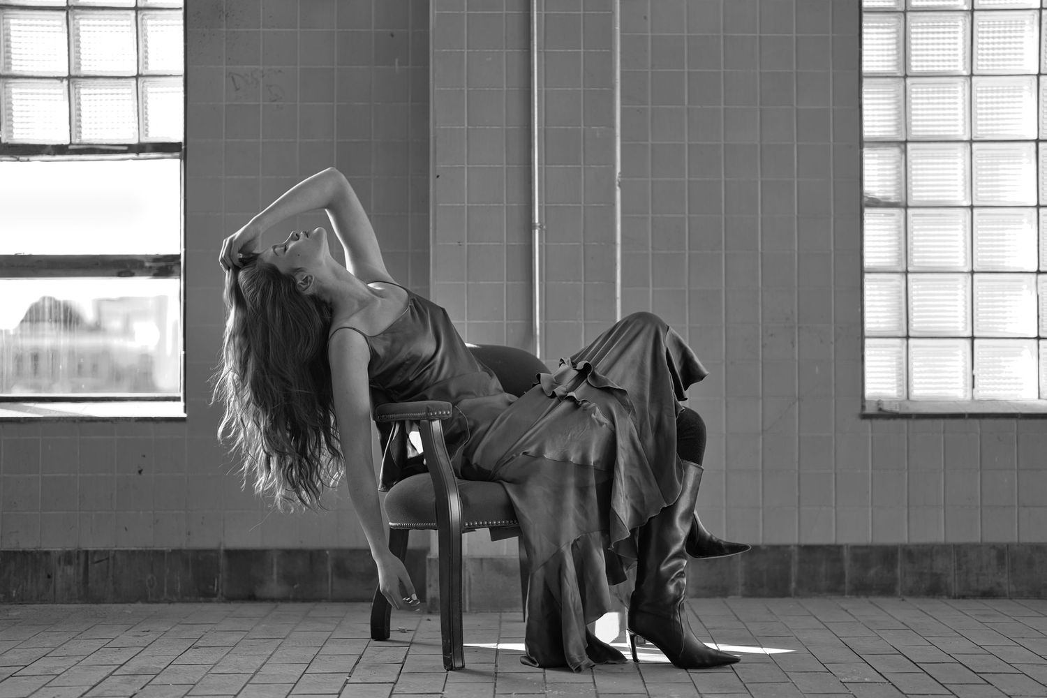 Woman sitting in chair leaning back.
