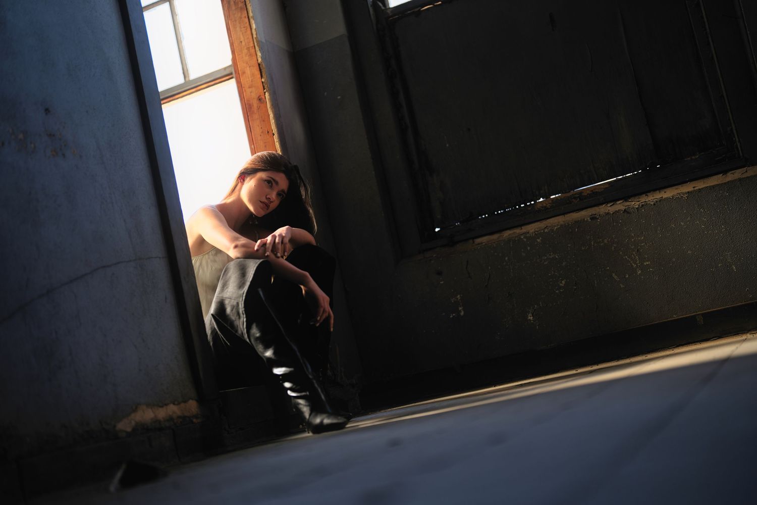 Woman sitting on doorway silhouette.