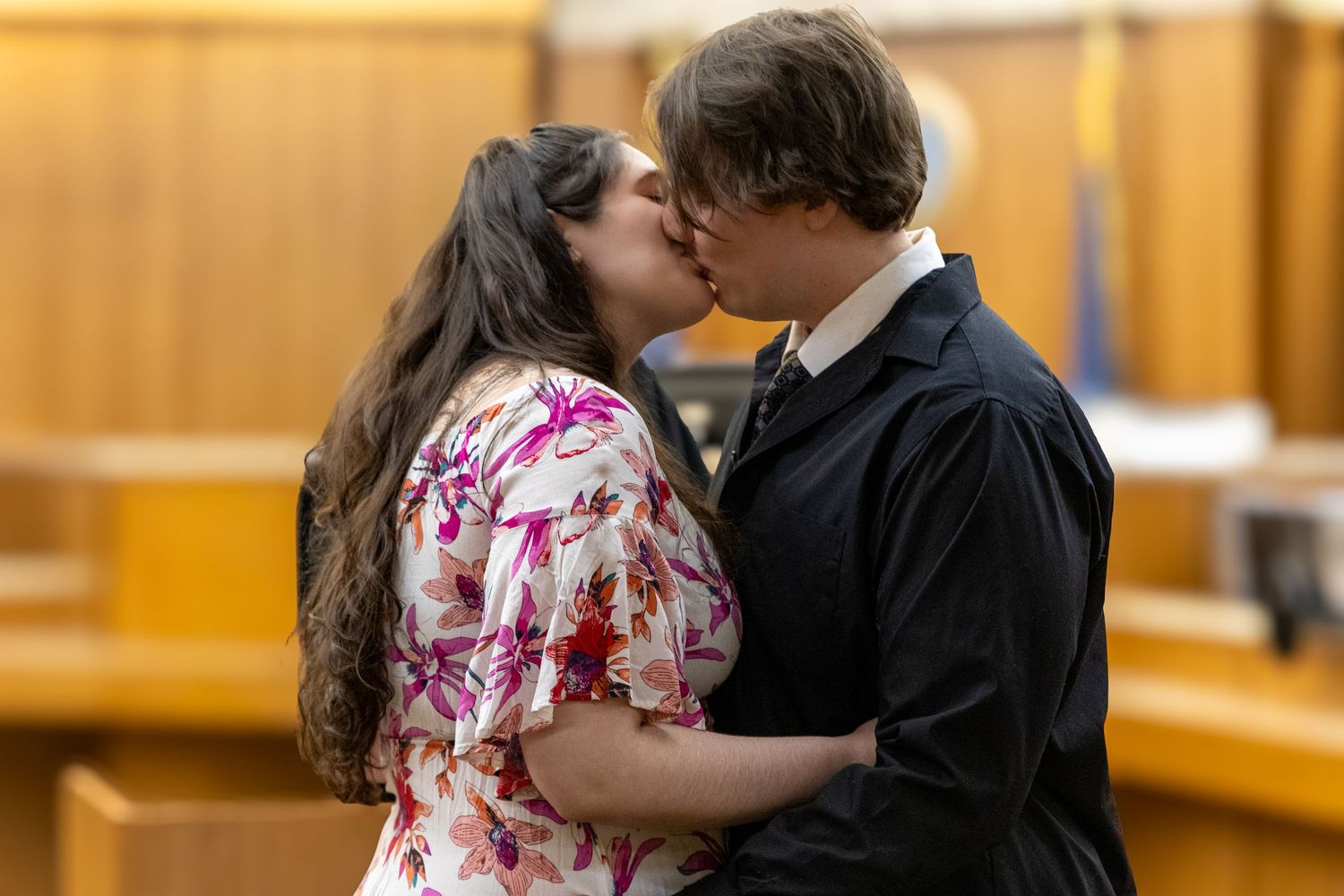 Couple sharing a first kiss as newlyweds in a courthouse ceremony.