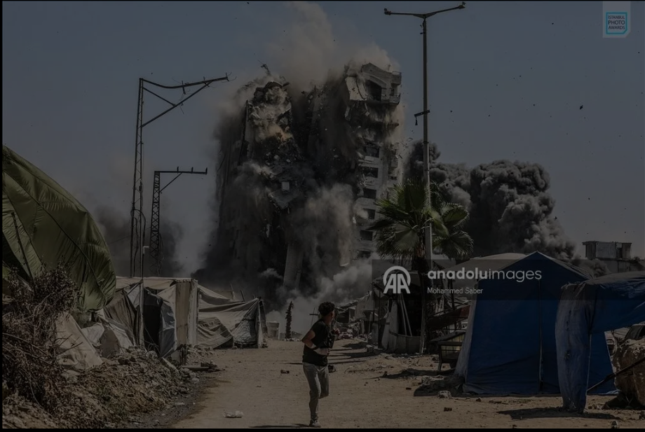 A boy runs as the Mushtaha Tower collapses following an Israeli airstrike in western Gaza City, Sept. 5, 2025.
