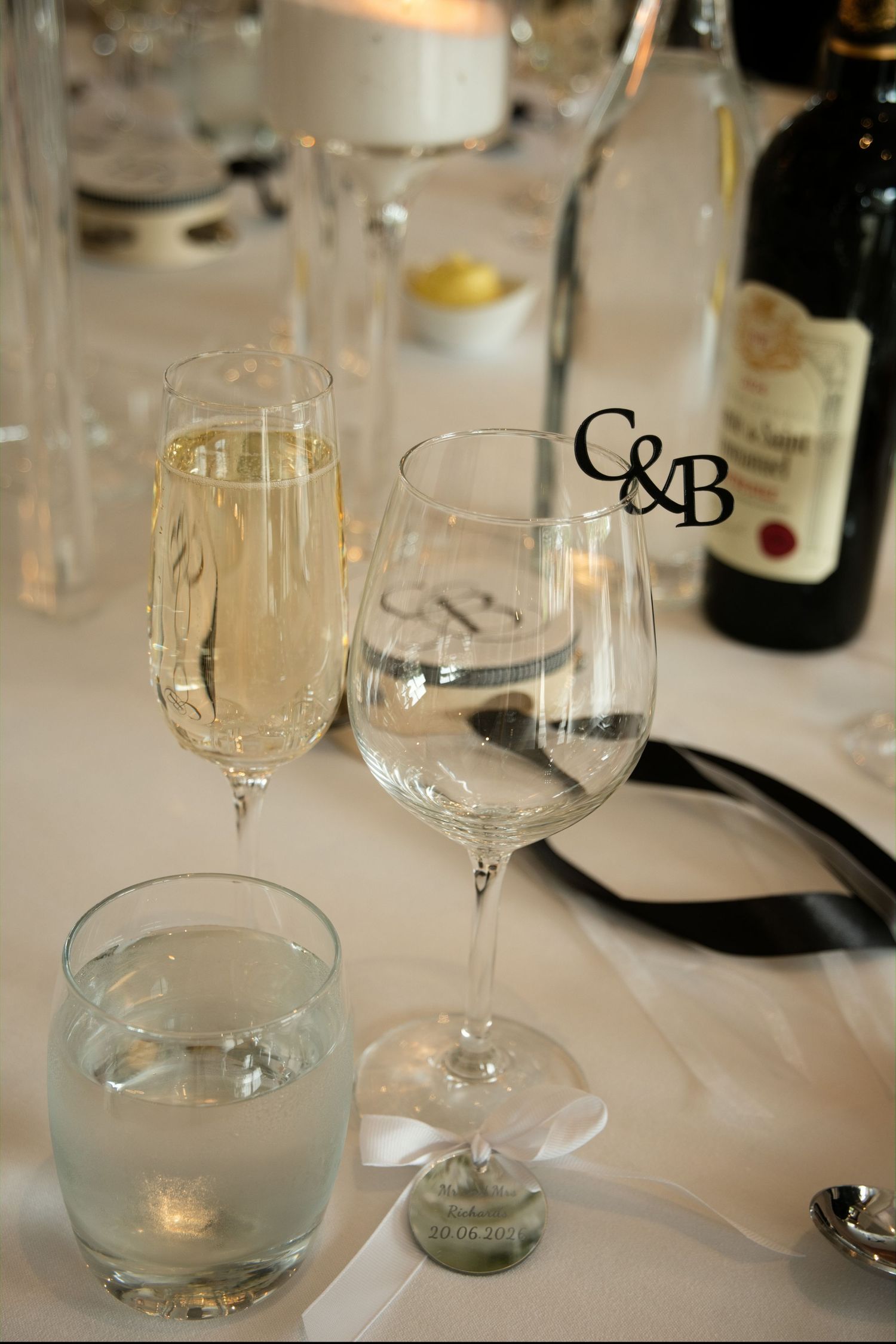 Wedding table setting with champagne flute, wine glass, and C&B monogram decor.