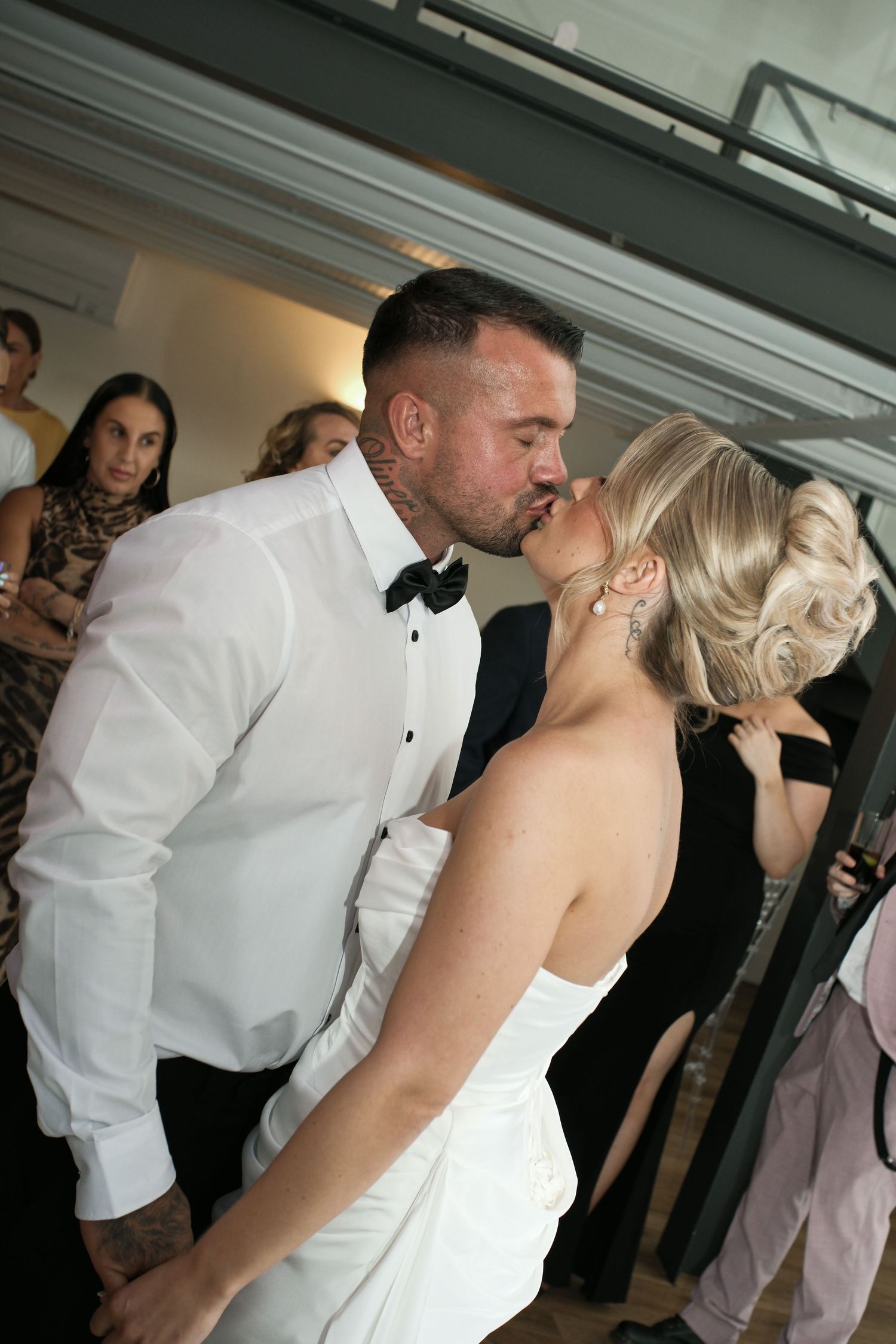 Bride and groom sharing a kiss on the dance floor at wedding reception.
