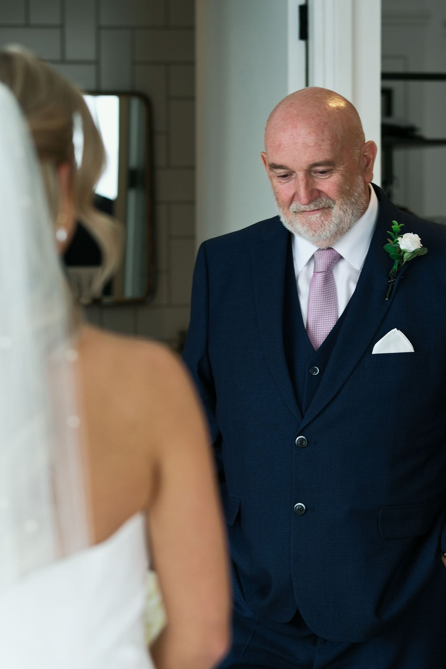 Emotional father seeing his daughter in her wedding dress for the first time during bridal prep.