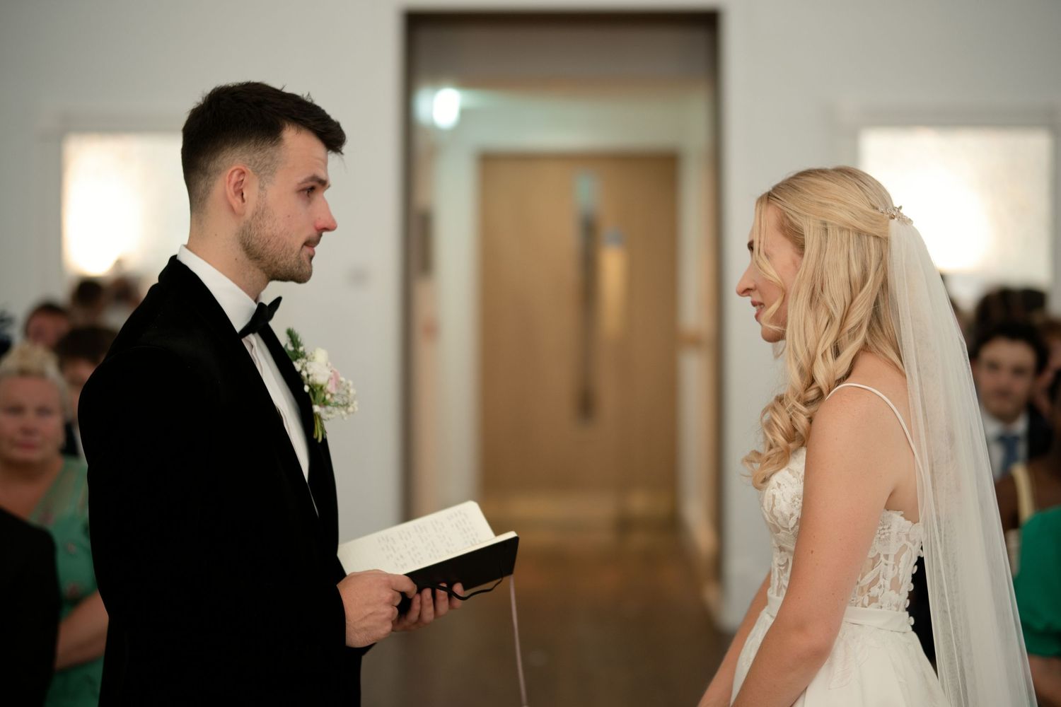 Bride and groom exchanging vows at elegant church wedding ceremony altar.