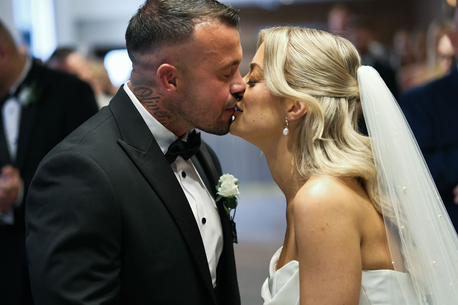 Newlywed couple sharing their first kiss as husband and wife during wedding ceremony.