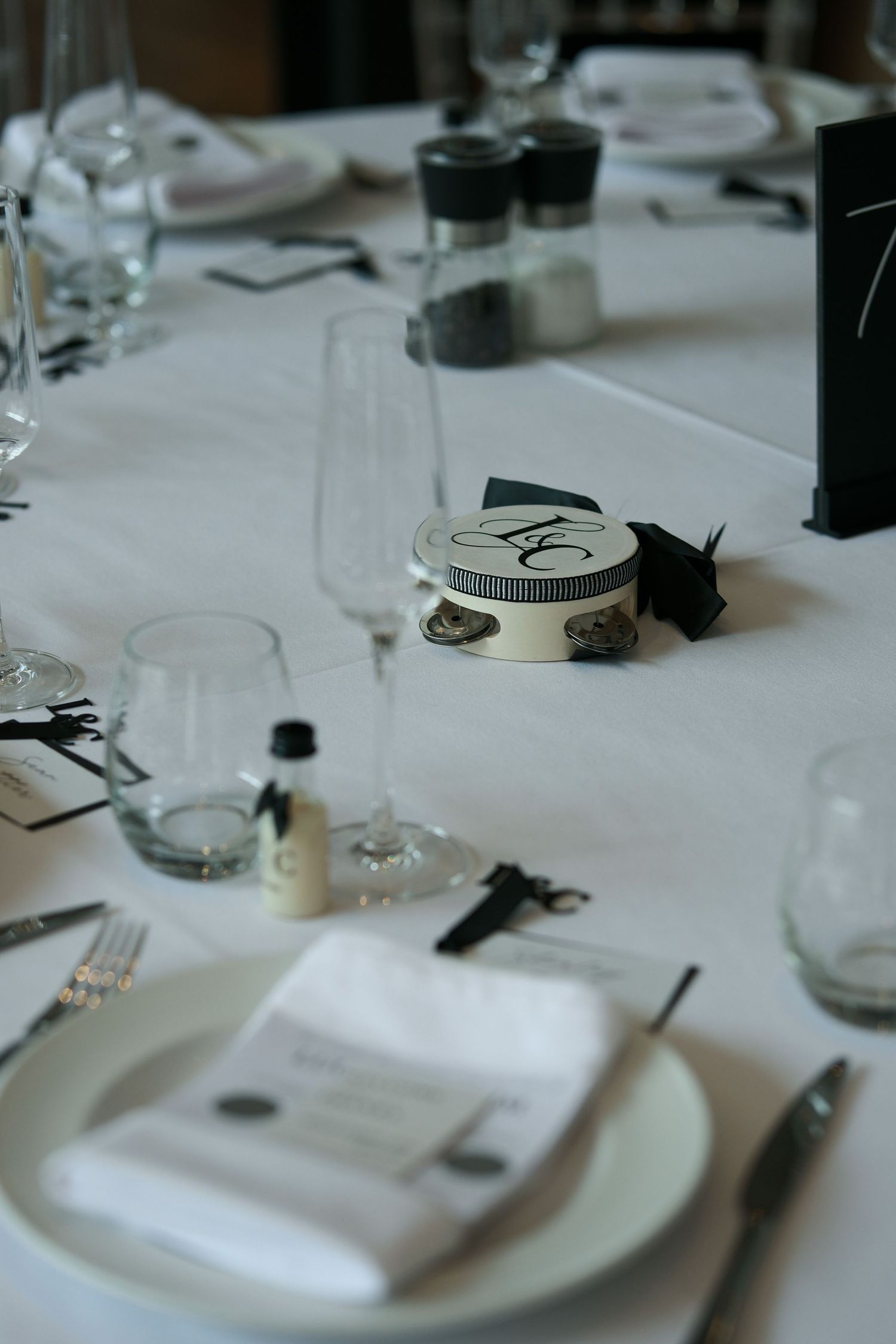 Elegant wedding reception table setting with champagne flutes and monogram favor box.