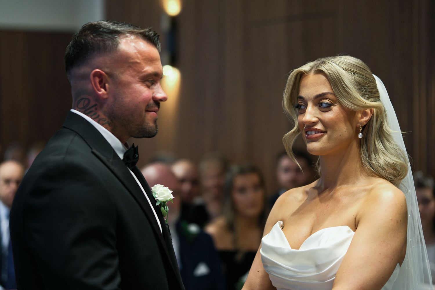 Bride and groom exchanging loving glances during their wedding ceremony at the altar.