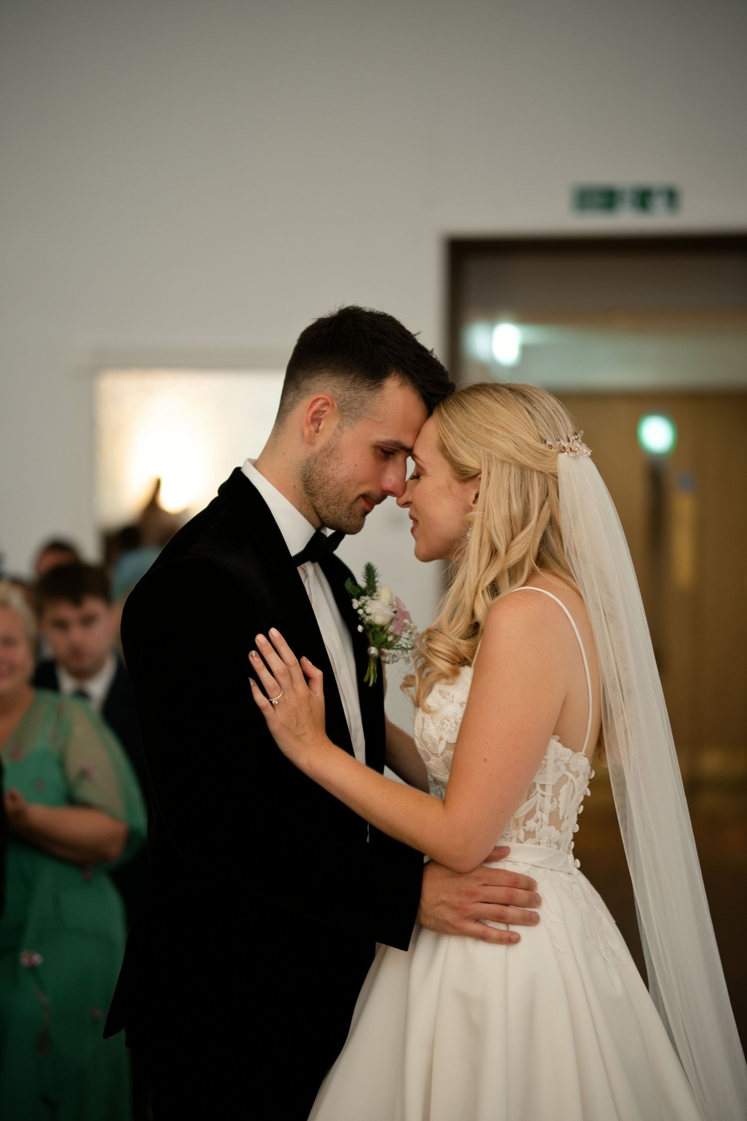 Bride and groom sharing intimate forehead touch moment during wedding ceremony.