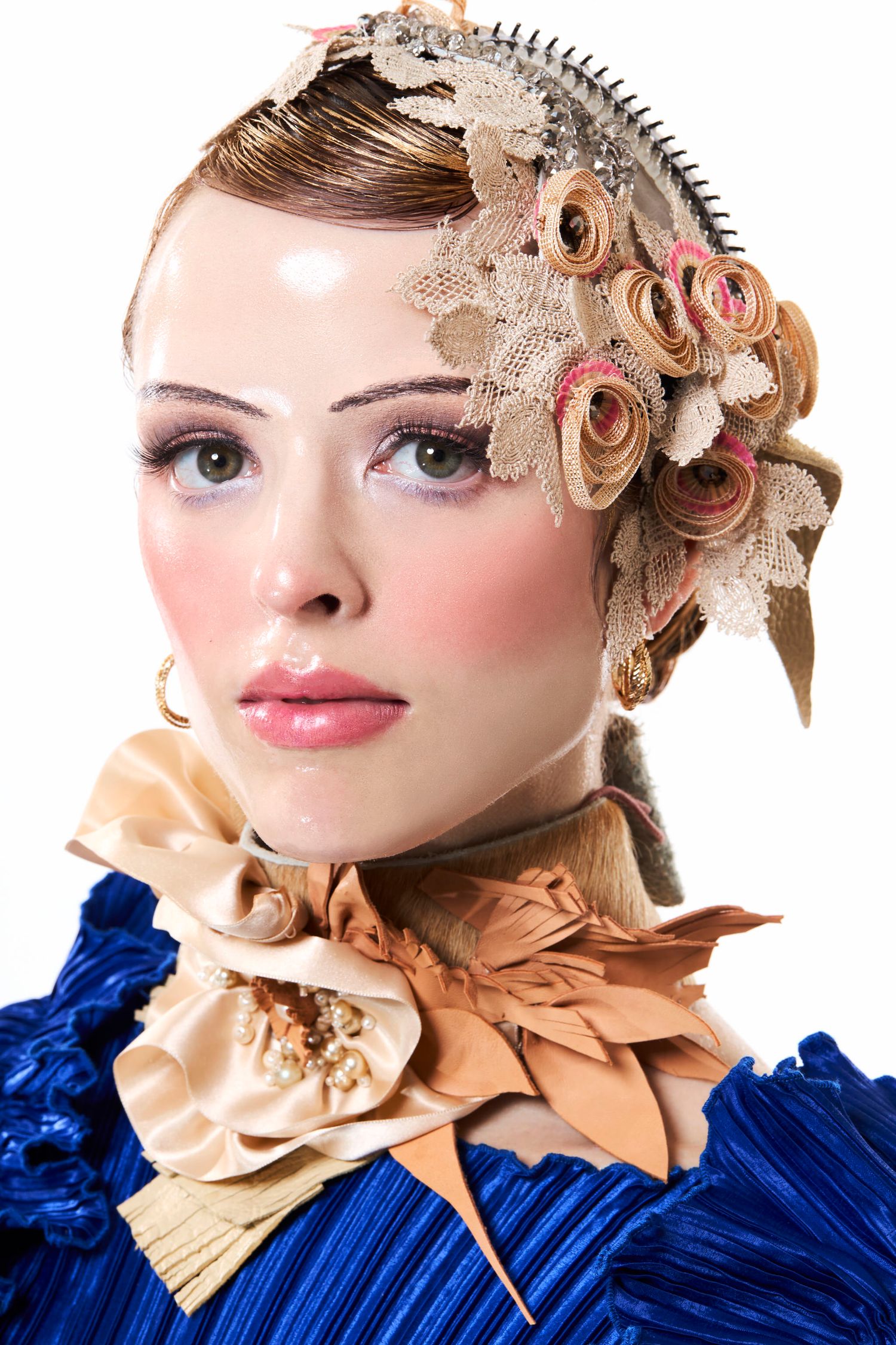 Woman in blue dress wearing ornate vintage headpiece with lace flowers and decorative neck ruff.