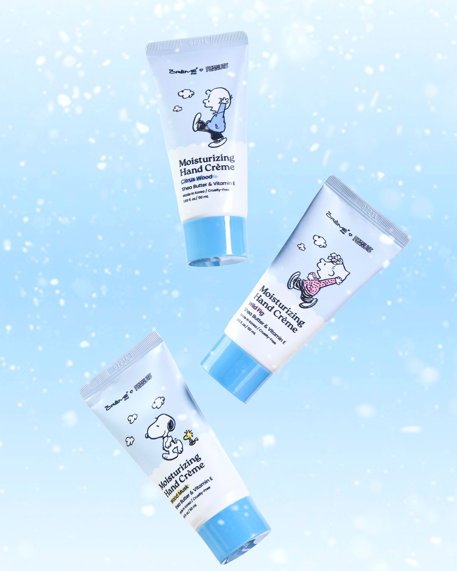 Three tubes of Moisturizing Hand Creme with Snoopy designs on a blue sparkly background.