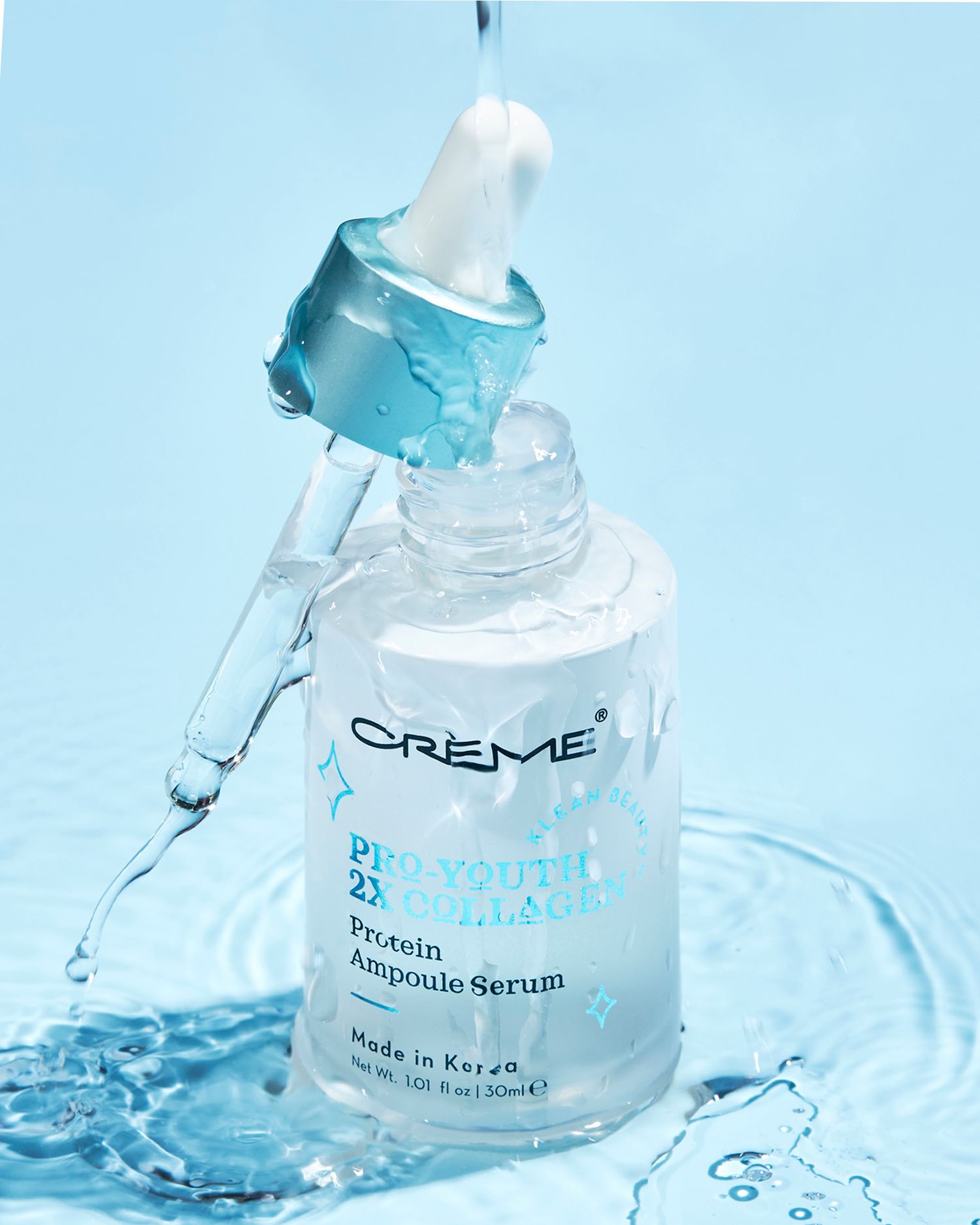 Crème Pro Youth Protein Ampoule Serum in a clear dropper bottle with water splashes on a light blue background.