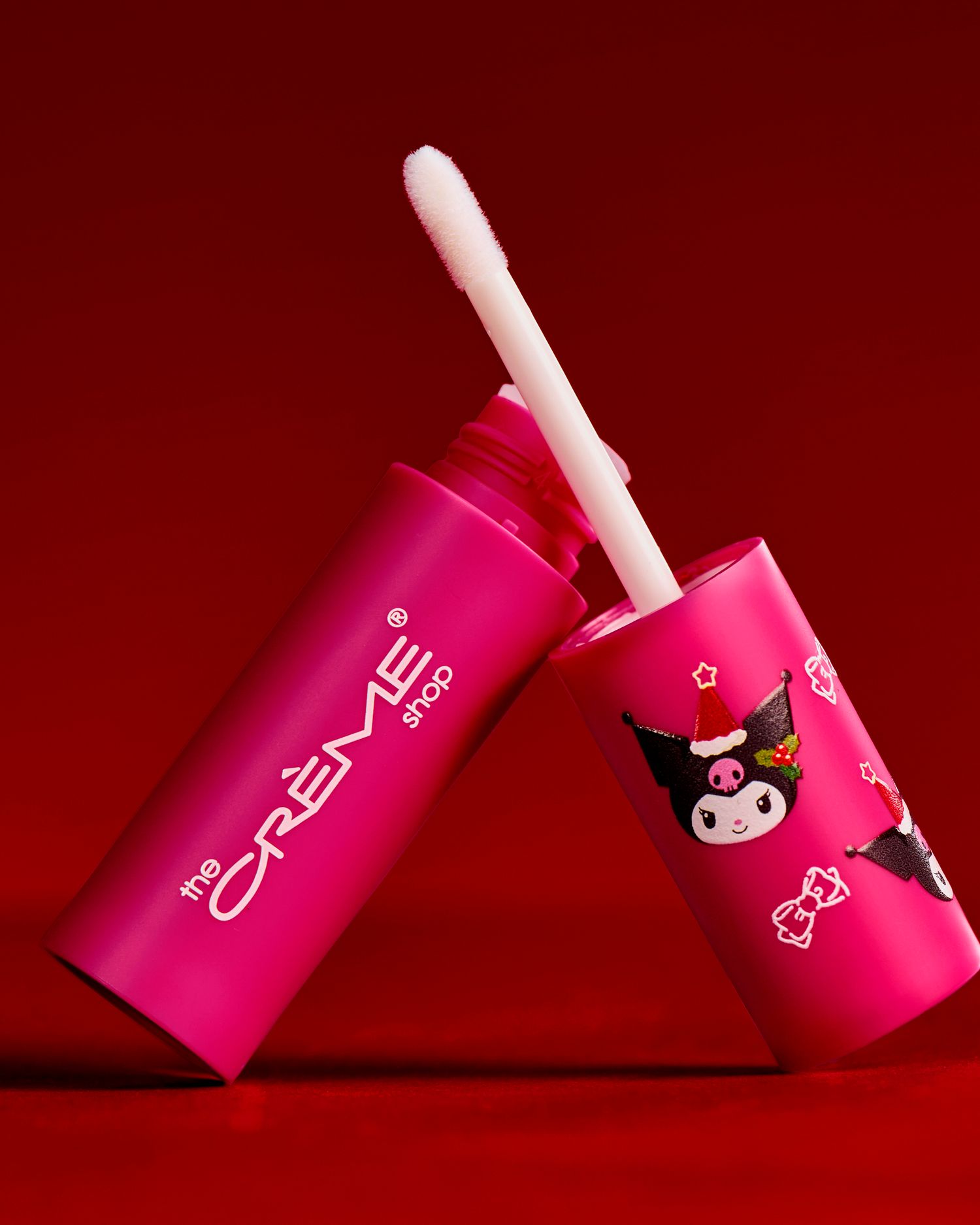 The Crème Shop hot pink lip gloss tube featuring Kuromi holiday design on red background.