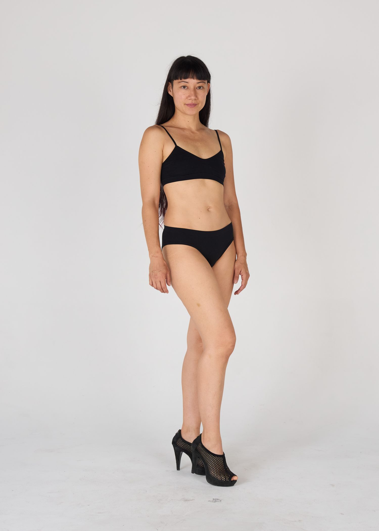 Full-length model digital session photo wearing a minimalist swimwear against a plain white wall, by Belva Chan.
