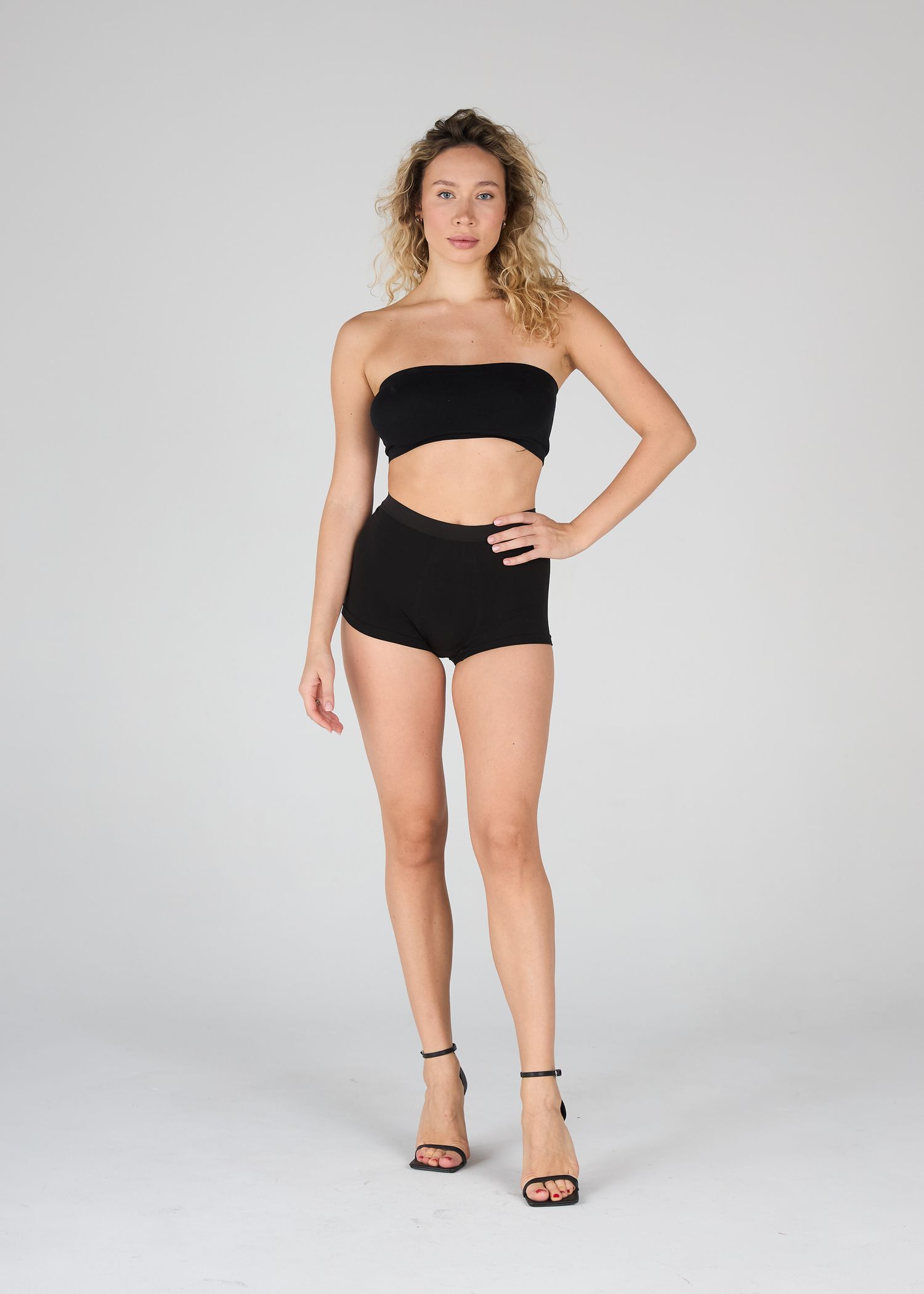 Full-length model digital session photo wearing a minimalist swimwear against a plain white wall, by Belva Chan.