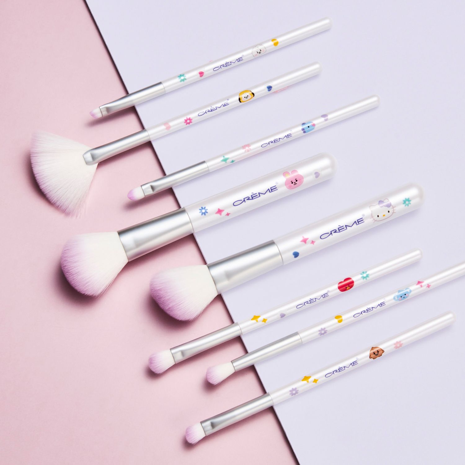 Set of 7 white makeup brushes with colorful candy print handles and soft pink bristles displayed on pastel background.