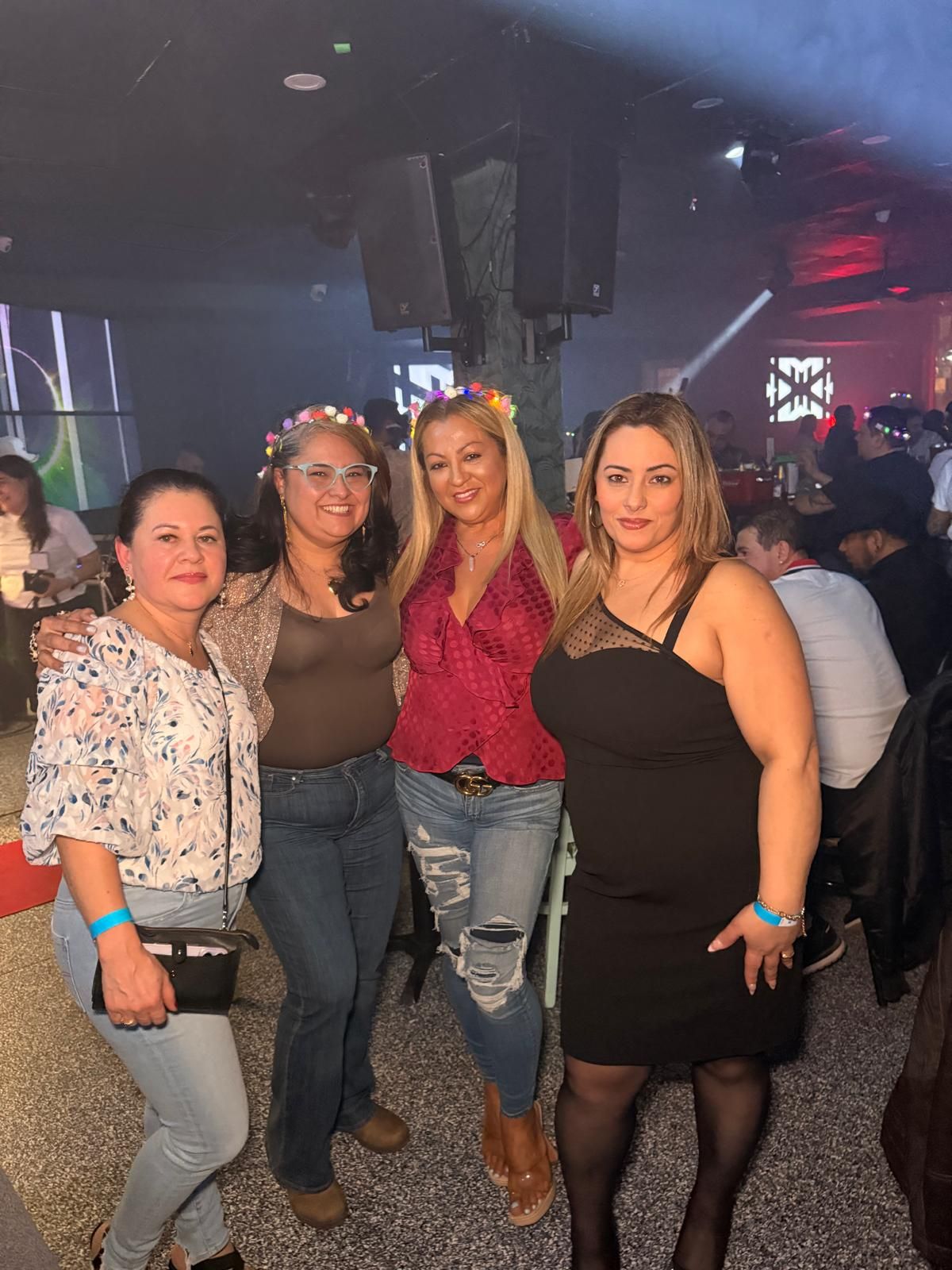 A group of people dancing and socializing together in a dimly lit nightclub or party venue.