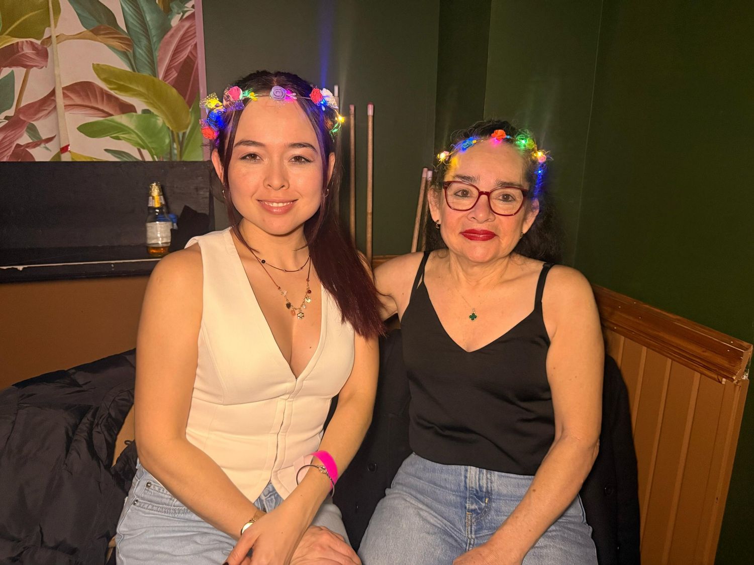 Friends sitting together at a restaurant table with tropical decor in the background.