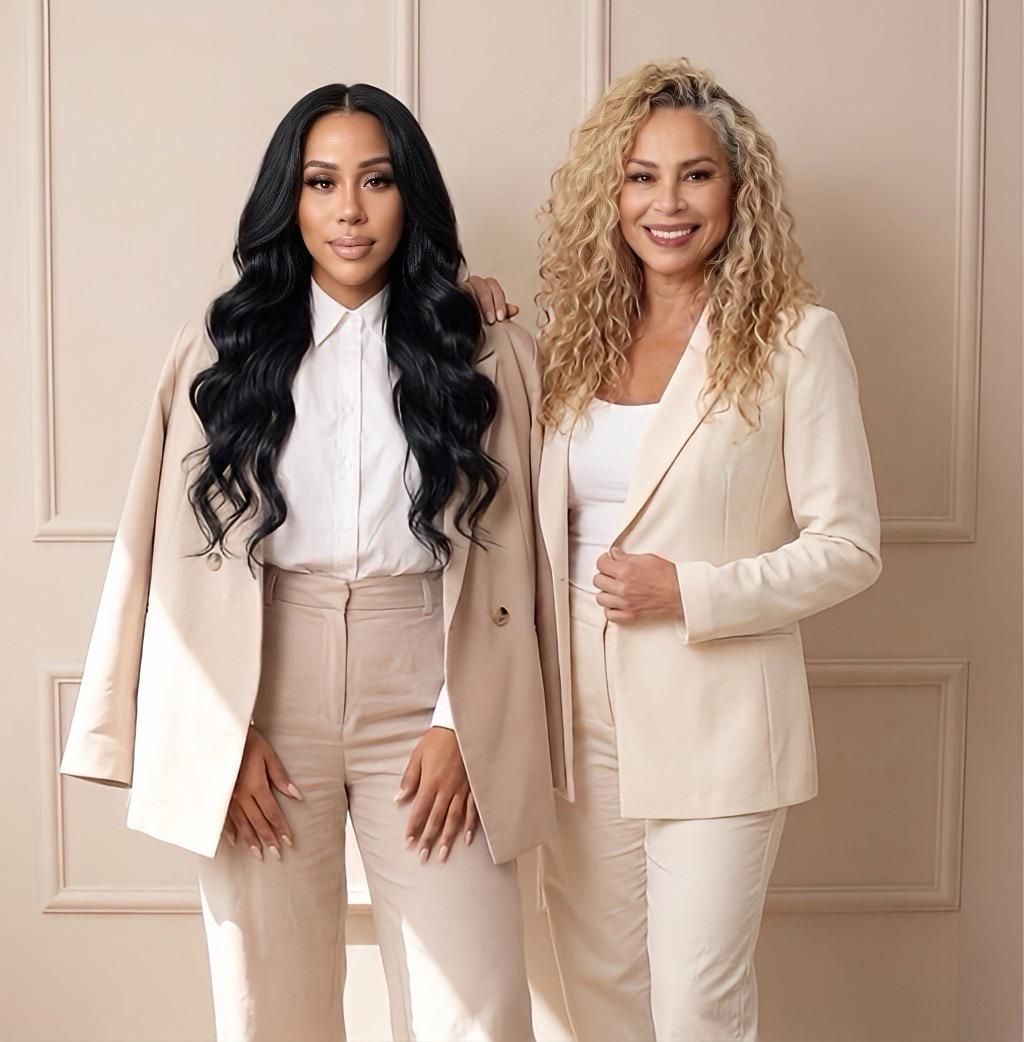 Professional business team wearing coordinated cream-colored suits poses against neutral backdrop.
