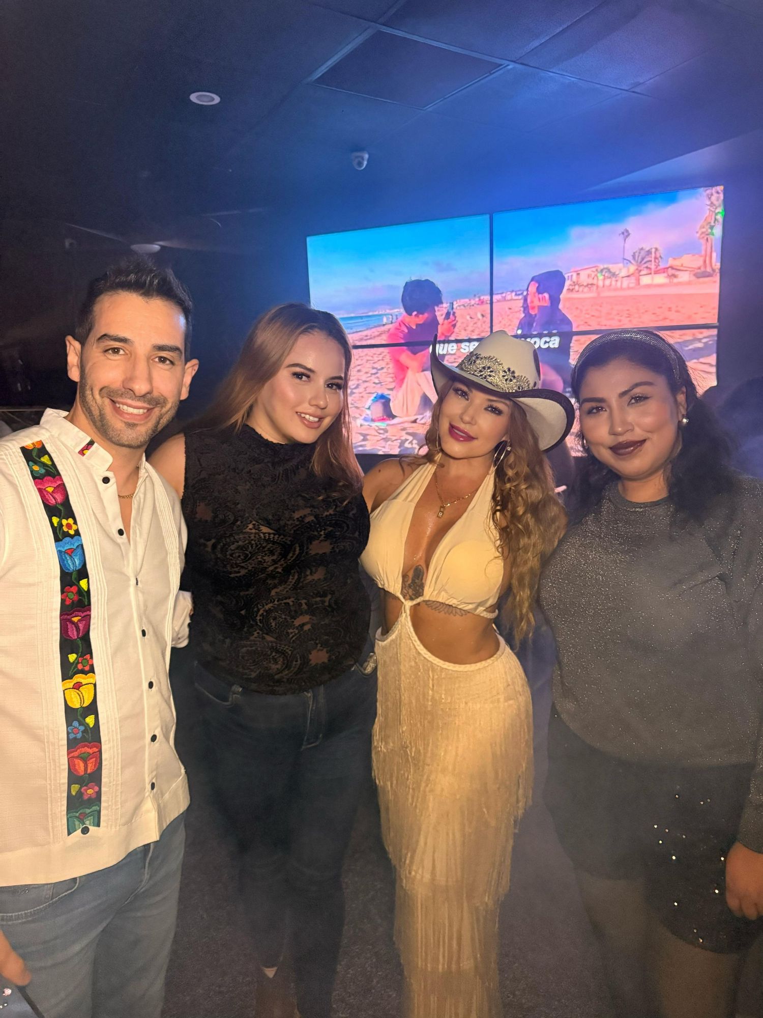 Group photo at a western-themed party with desert backdrop.