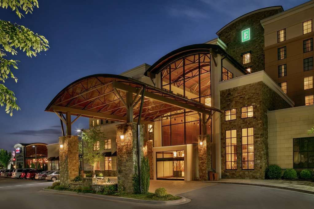 Modern luxury resort exterior with illuminated walkways and landscaping at dusk showcases contemporary architecture.