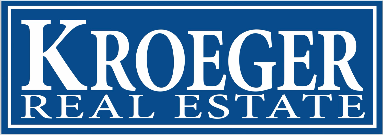 Blue and white rectangular logo for Kroeger Real Estate with text in capital letters against a navy blue border.