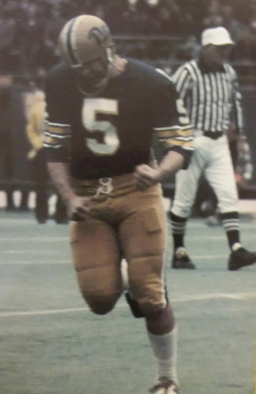 Football player wearing jersey number 5 in blue and gold uniform runs on field during a game.