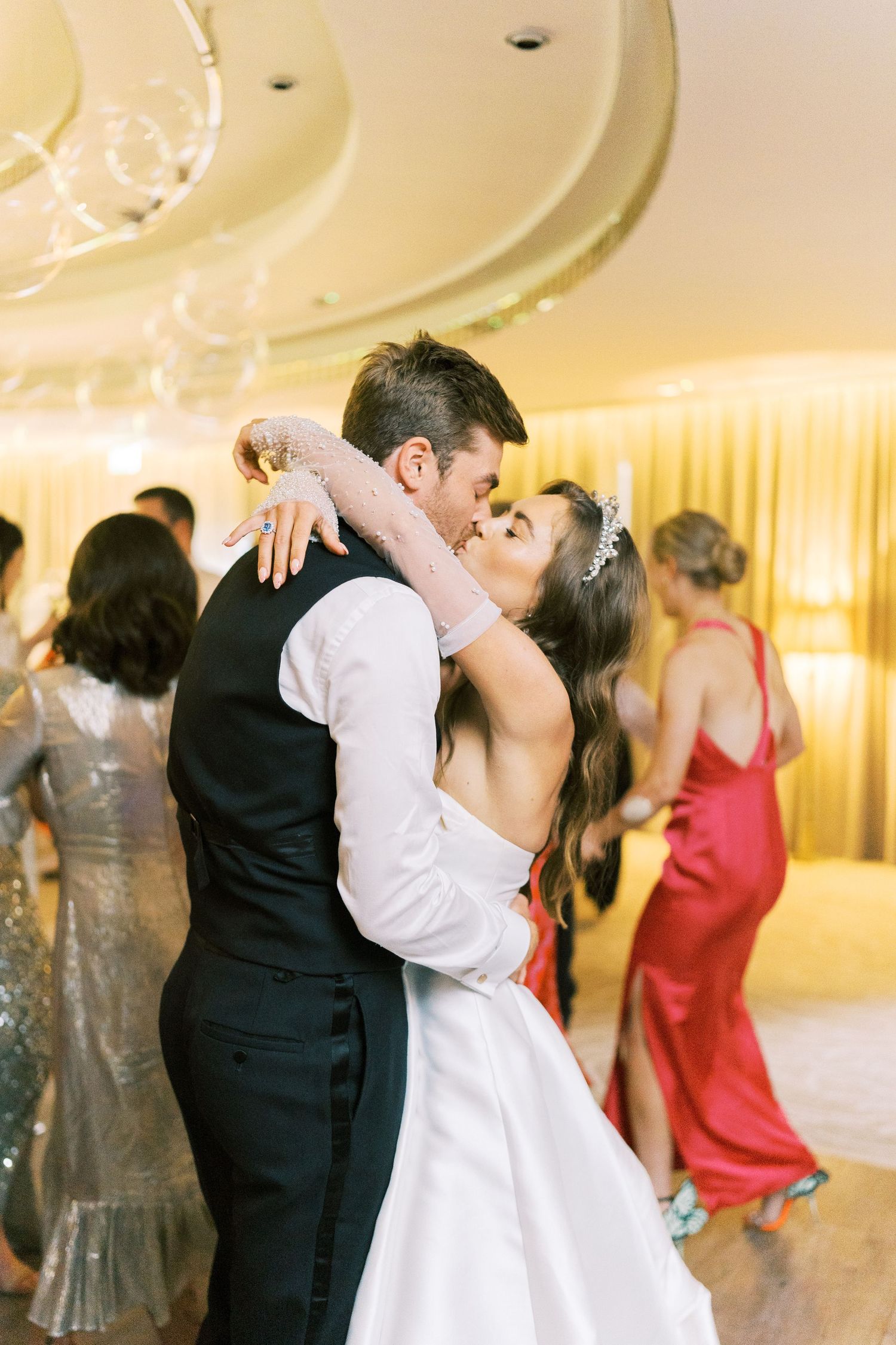 Bride and groom share a romantic first dance kiss at their elegant wedding reception.